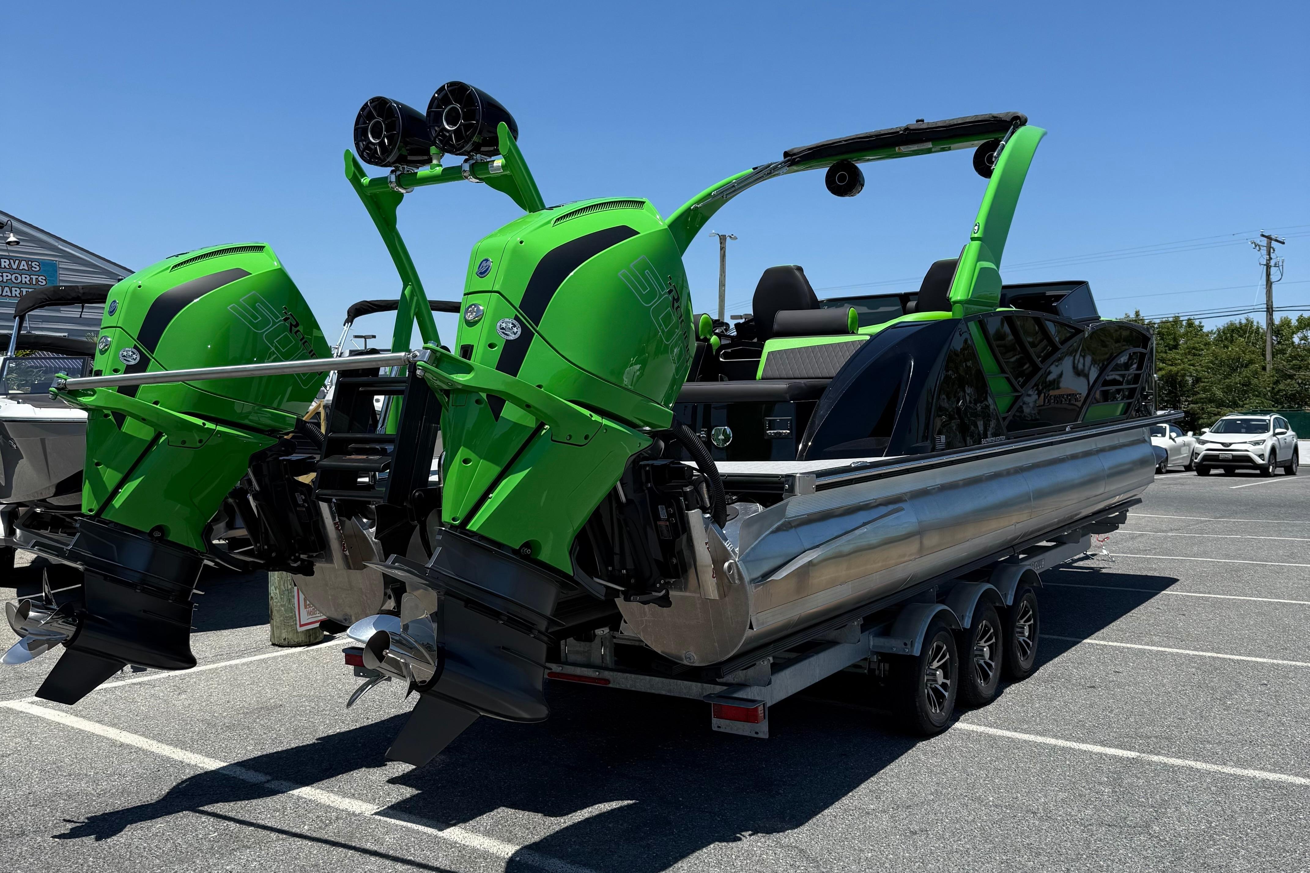 2026 Berkshire Sport SLX9 DC boat with dual green outboard motors in a parking lot.