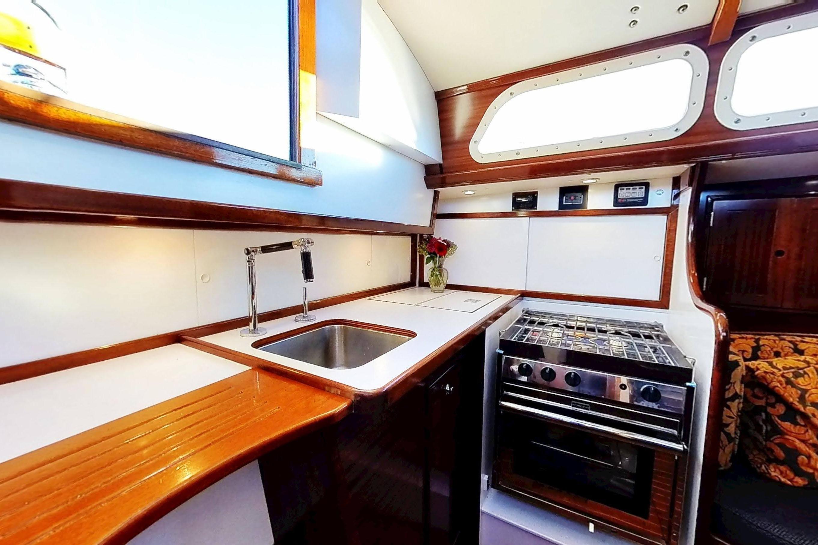 Hinckley Bermuda 40 yacht kitchen interior with stove, sink, and wooden cabinetry, 1970 model.