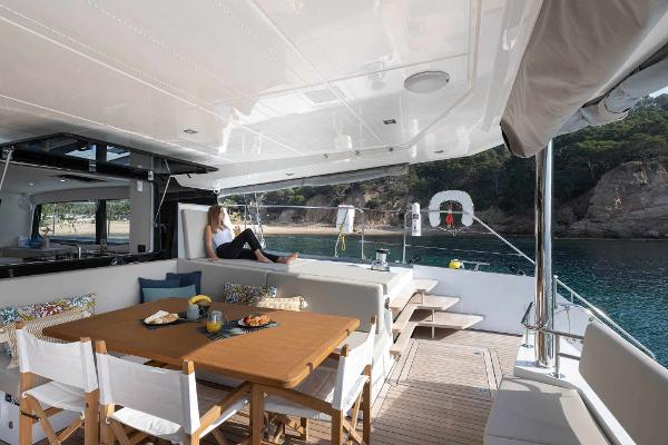 Luxurious 2025 Privilege Signature 580 yacht with elegant outdoor dining area and scenic ocean view.