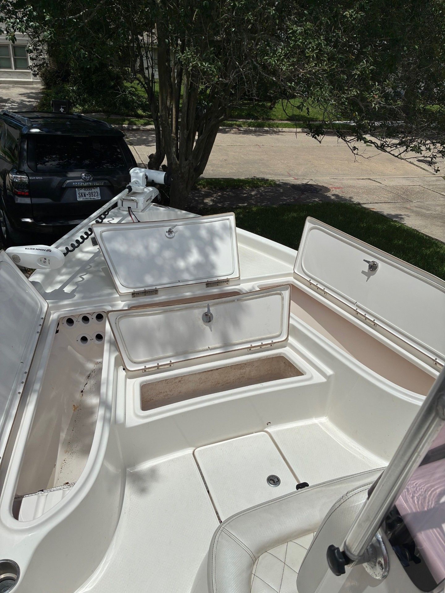 The image shows the deck of a 2018 Custom 2200 Pure Bay boat with open storage compartments.