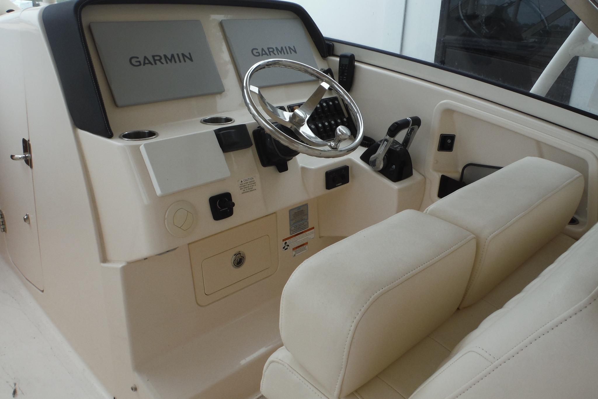 Helm of 2019 Grady-White Freedom 325 boat with Garmin displays and steering wheel.