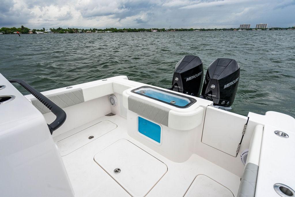 2027 Reef Runner 280 boat with dual Mercury engines on a calm lake.