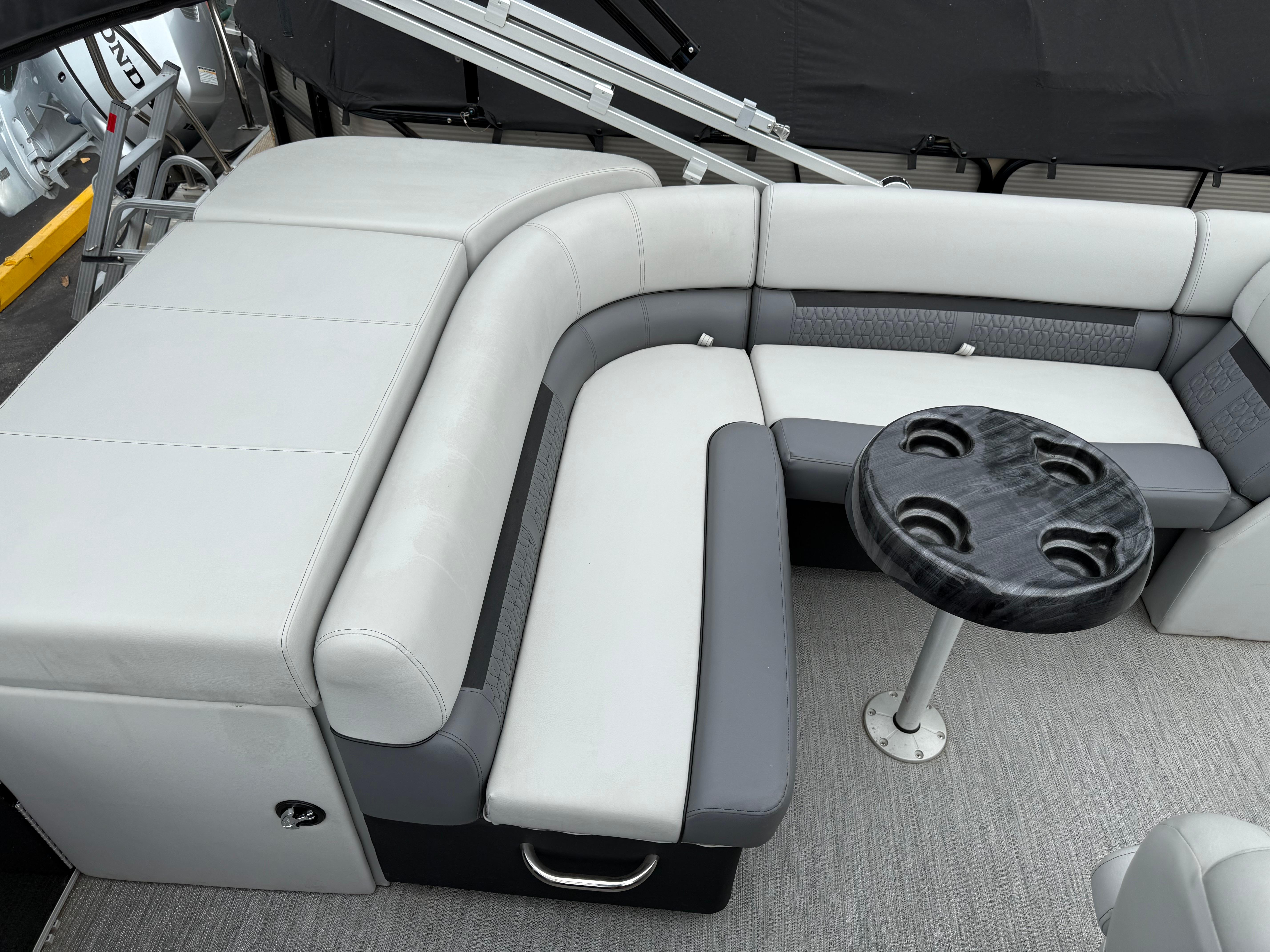 2023 Godfrey Sweetwater boat interior with gray seating and a round table.