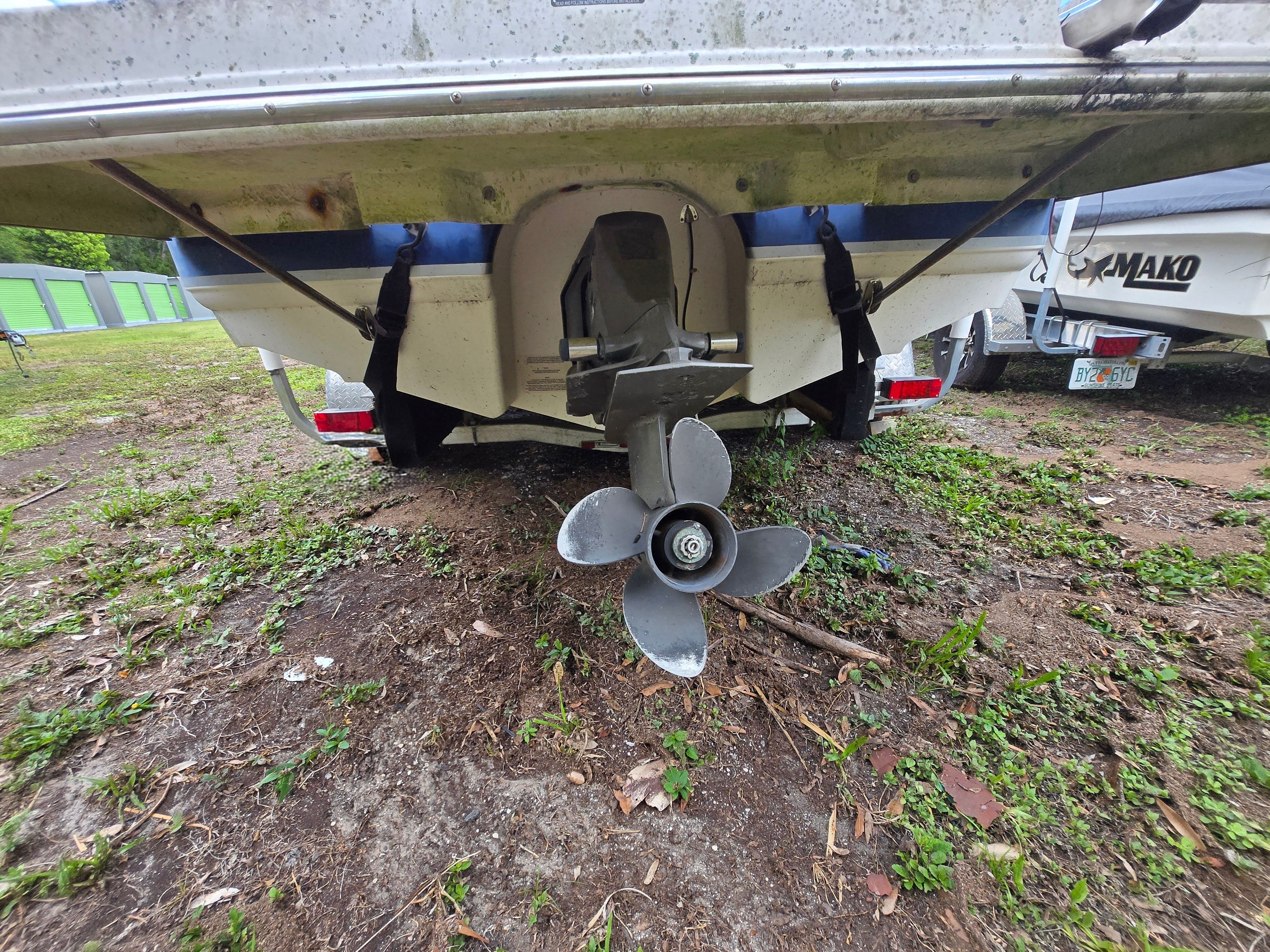 The image shows the stern of a boat with a propeller on dry land.