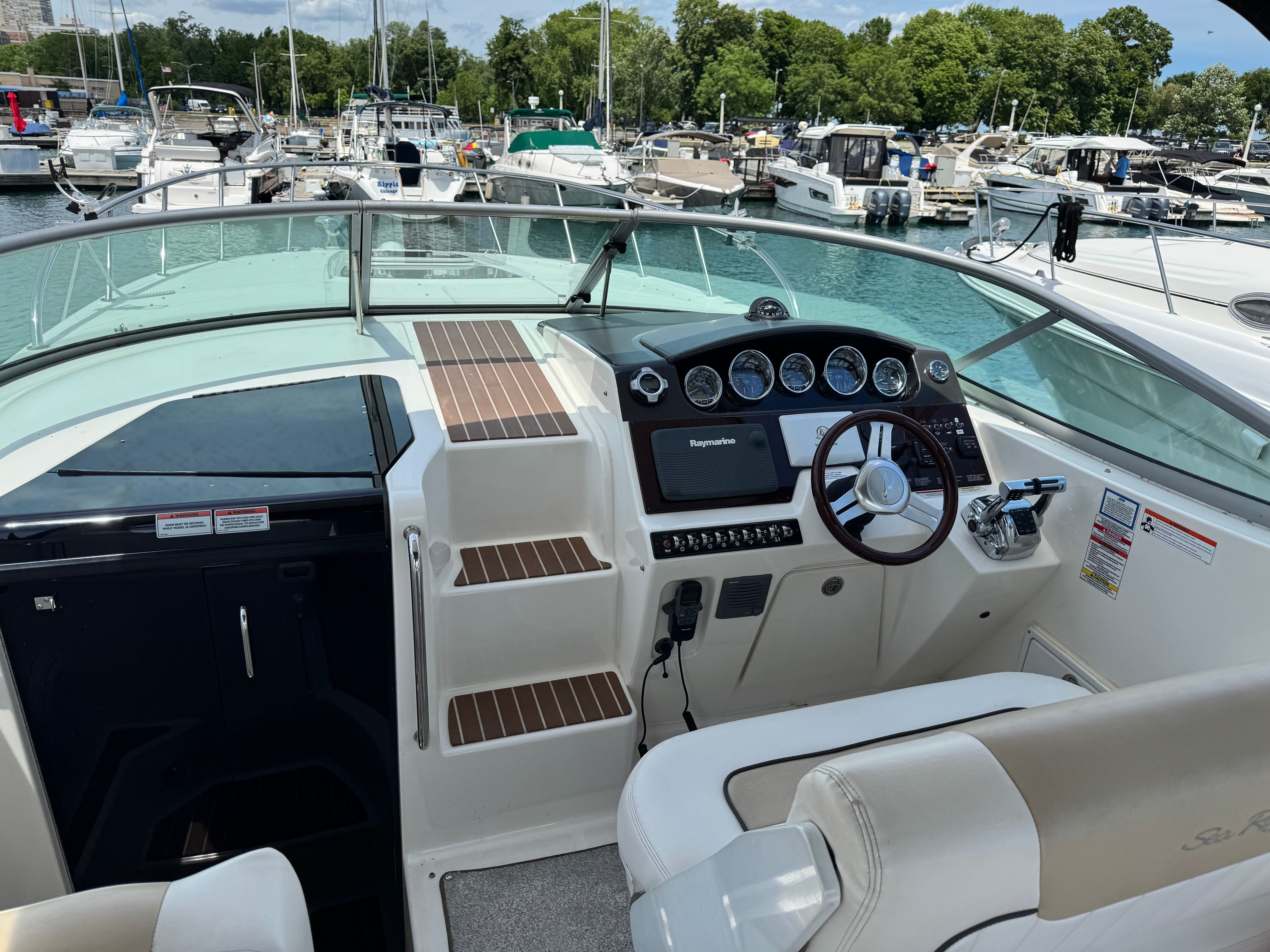 The cockpit of a 2010 Sea Ray Sundancer 310 in a marina.