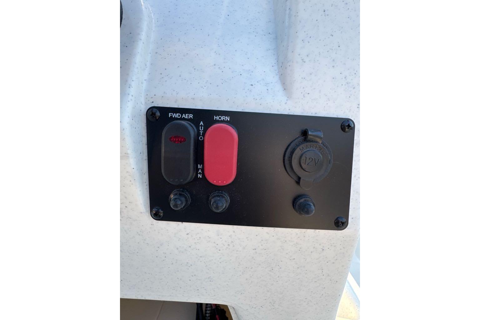 Control panel of 2026 Mako Pro Skiff 13 CC with switches and 12V outlet.