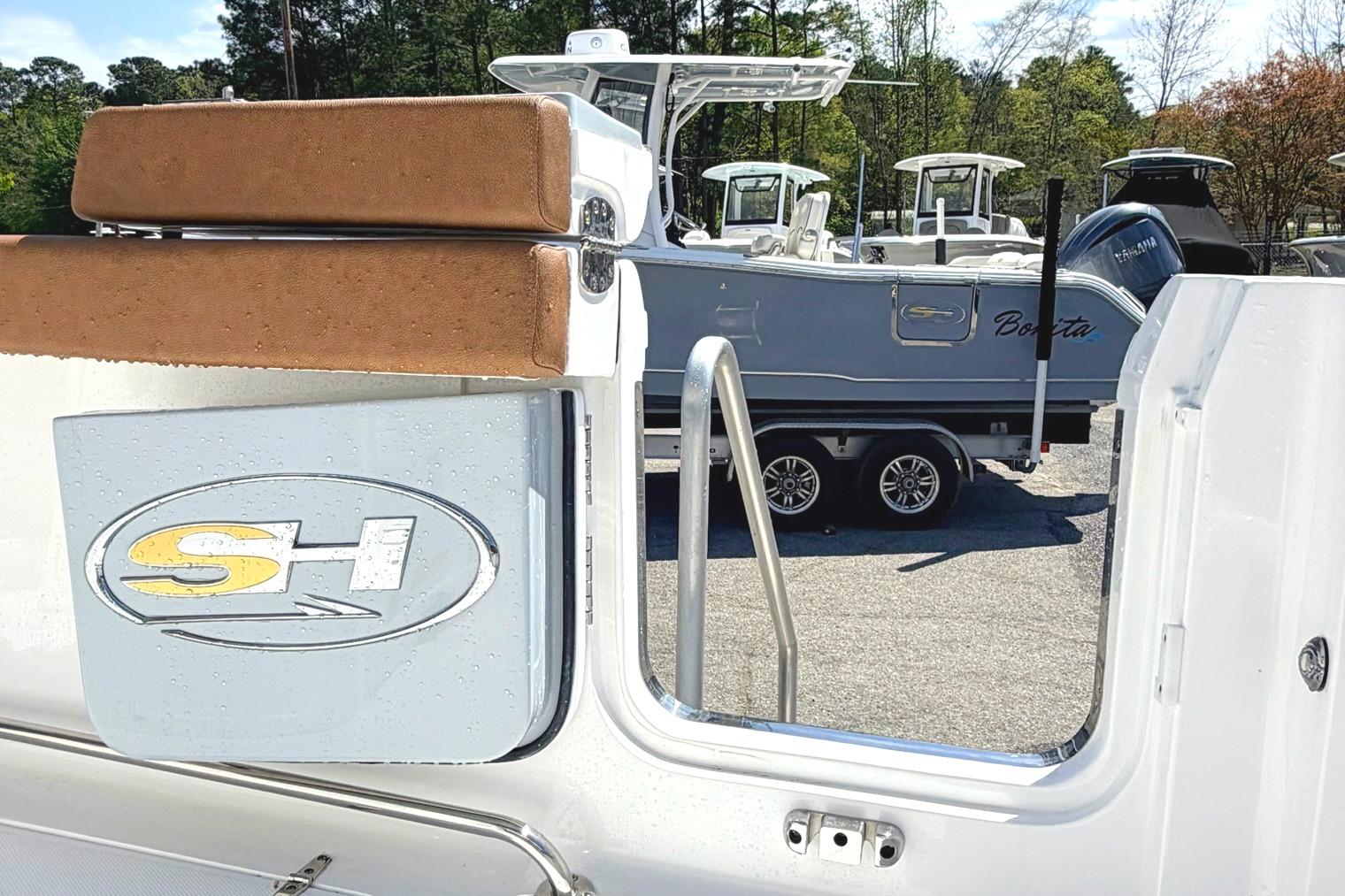 Seahunt Ultra 305 CB 2026 boat with logo, parked on a trailer in a marina.