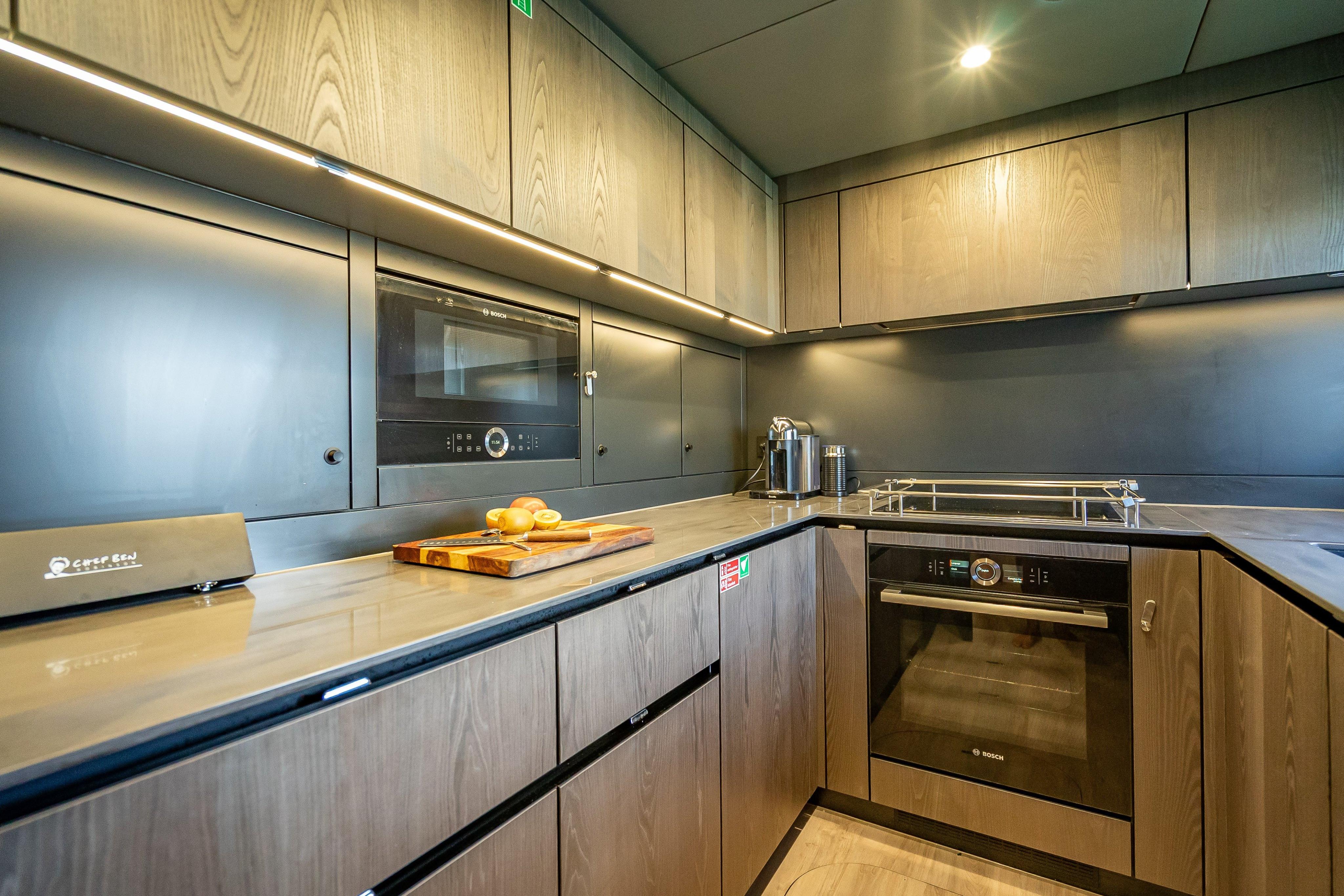 Modern kitchen interior on 2026 Sunreef 60 Power yacht, featuring sleek cabinetry and appliances.