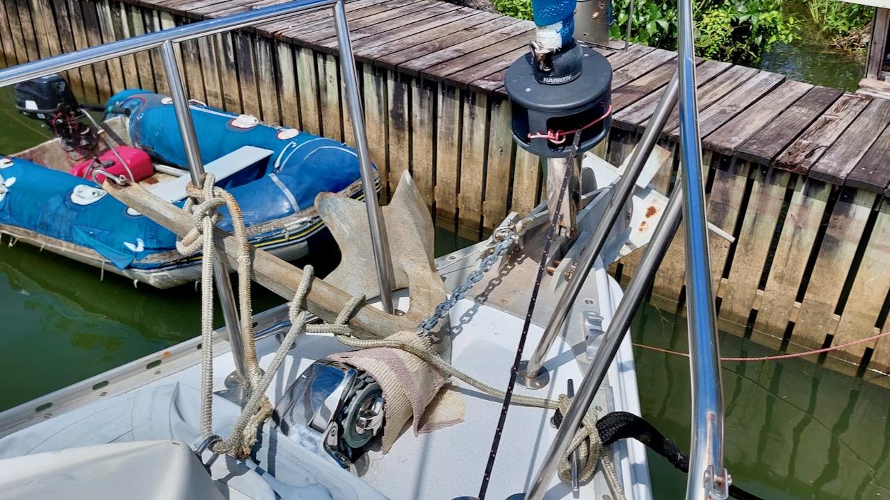 1981 Morgan Out Island 41 sailboat bow with anchor and ropes, docked near wooden pier.
