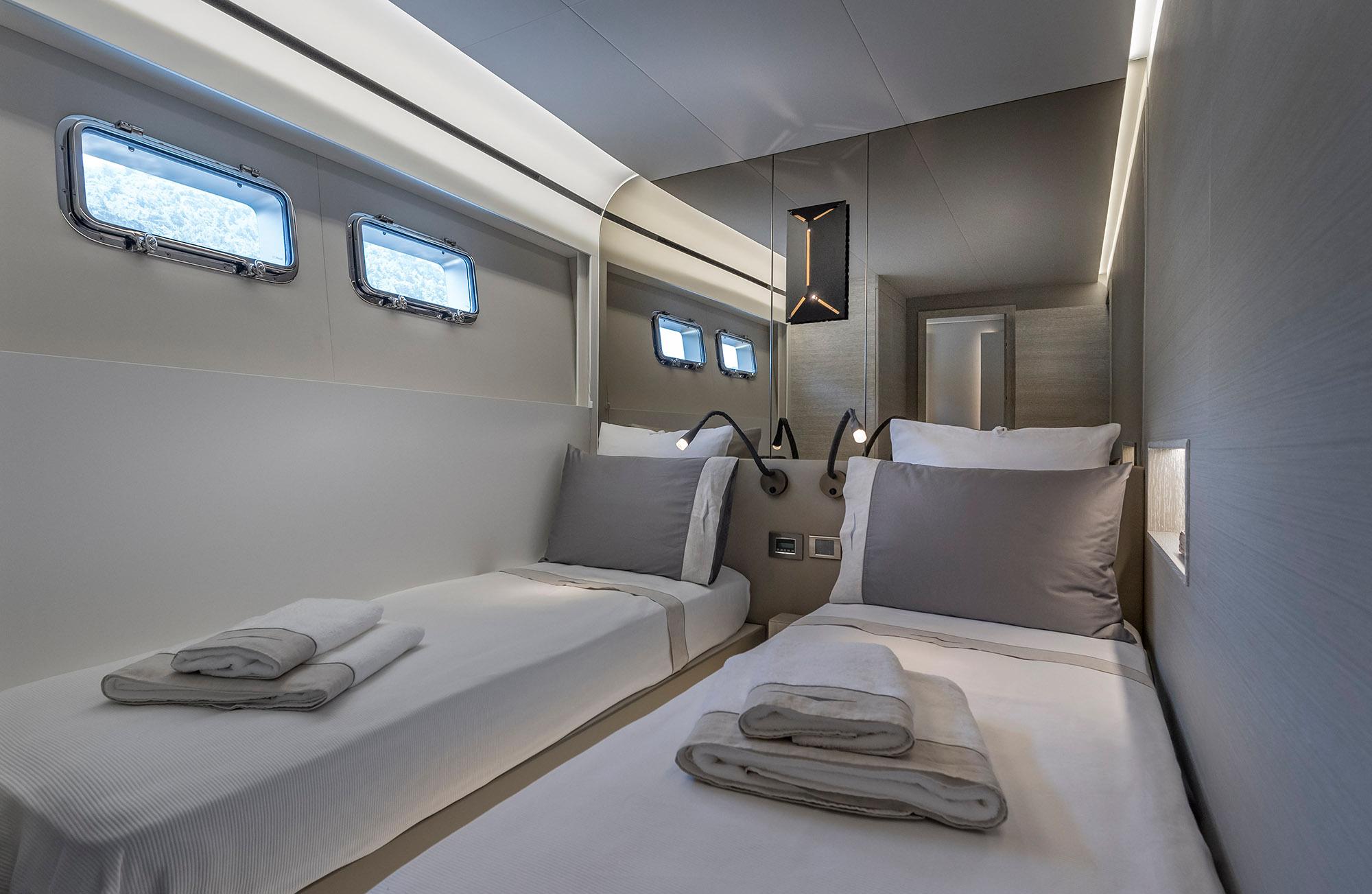 Luxurious twin cabin interior of 2025 Numarine 26XP yacht with modern design and ambient lighting.