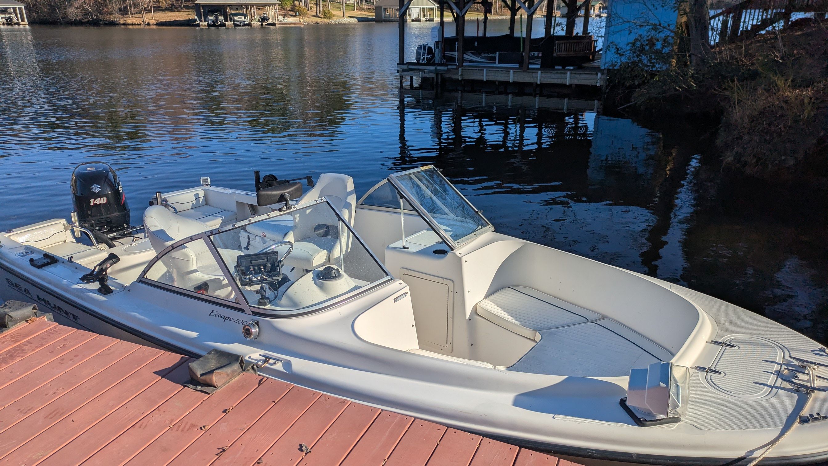 Sea Hunt Escape 2000 motorboat docked, calm water.