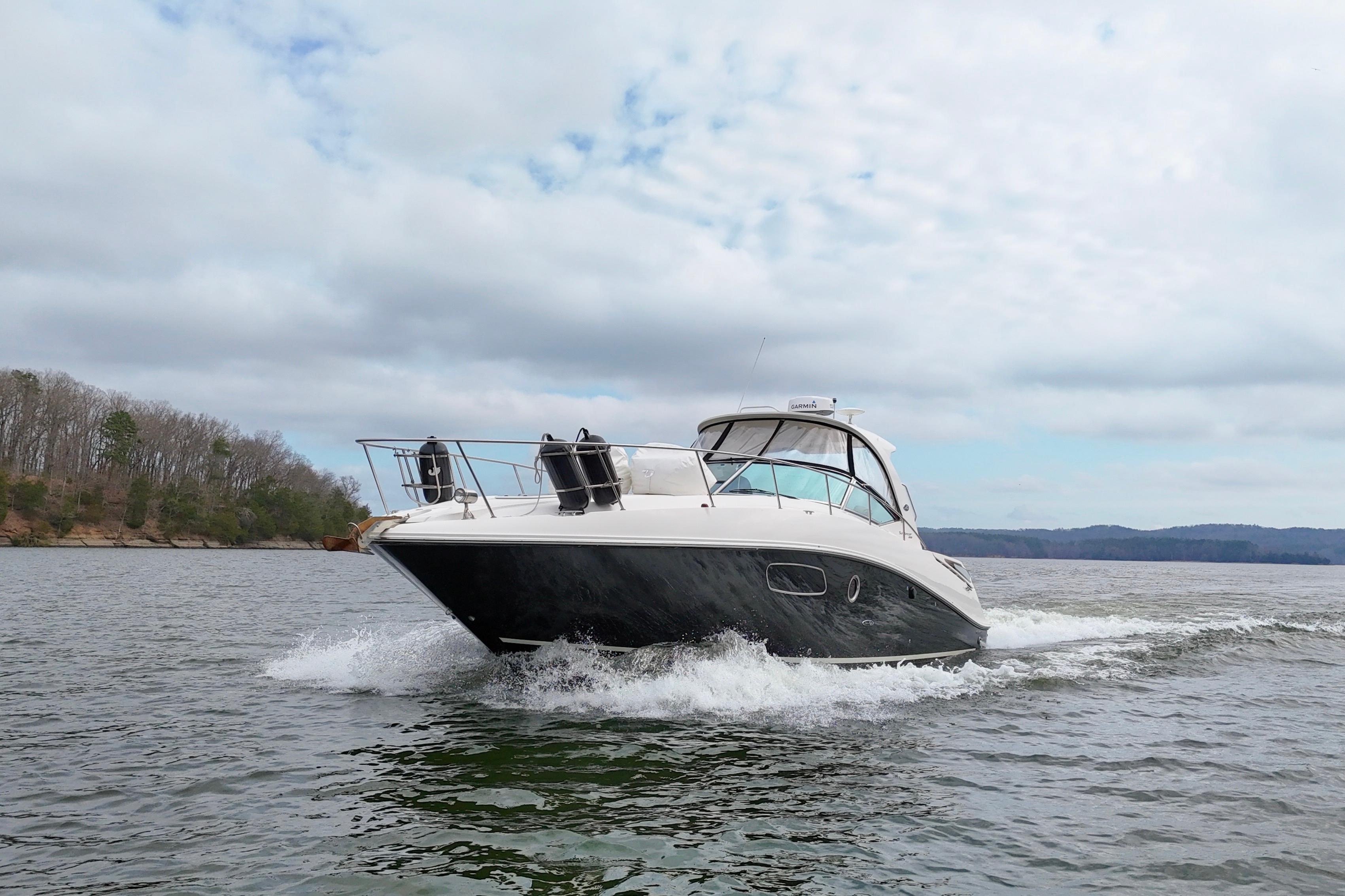 2009 Sea Ray Sundancer 350 cruising on a scenic lake under cloudy skies.