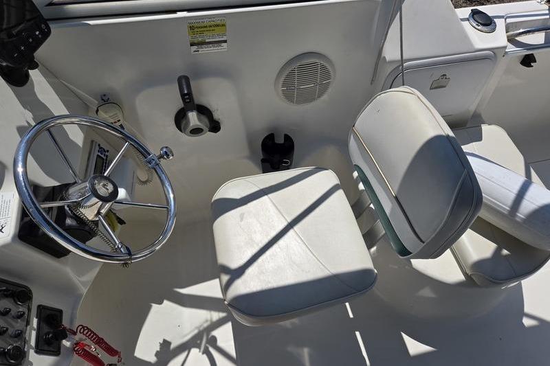 2004 Aquasport 215 Osprey Sport boat interior with steering wheel and seating.