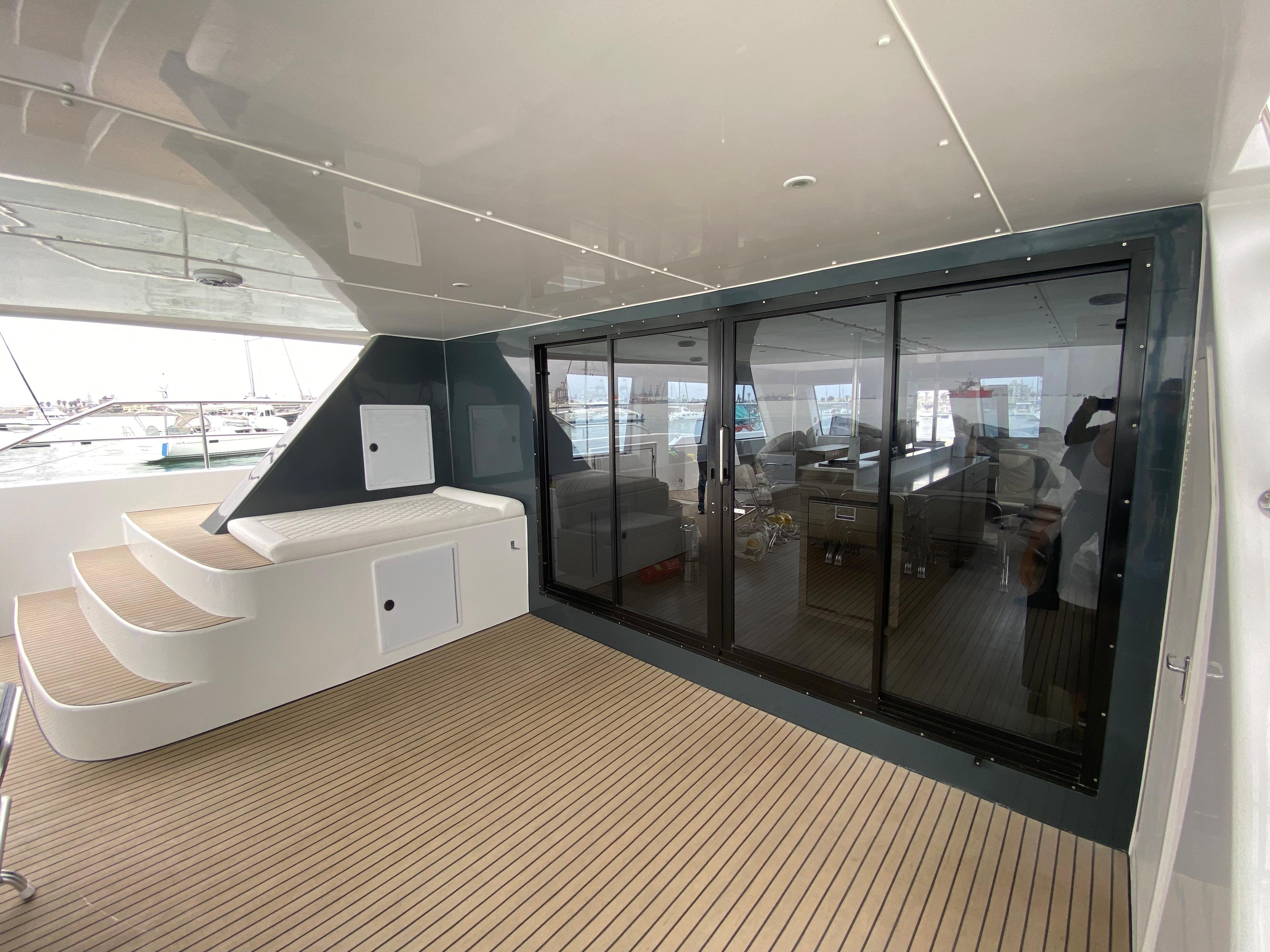 Spacious deck of 2022 Ballotta KSS P65 Powercat with modern sliding glass doors.