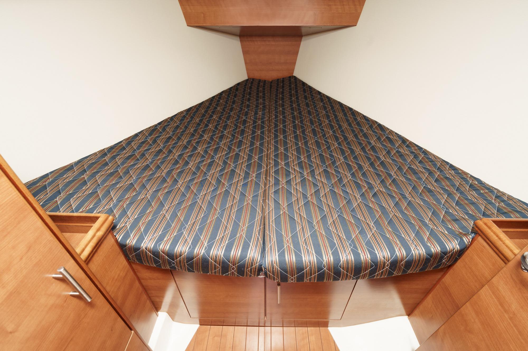 2015 Hunter 33 yacht interior with patterned bed and wooden cabinetry.