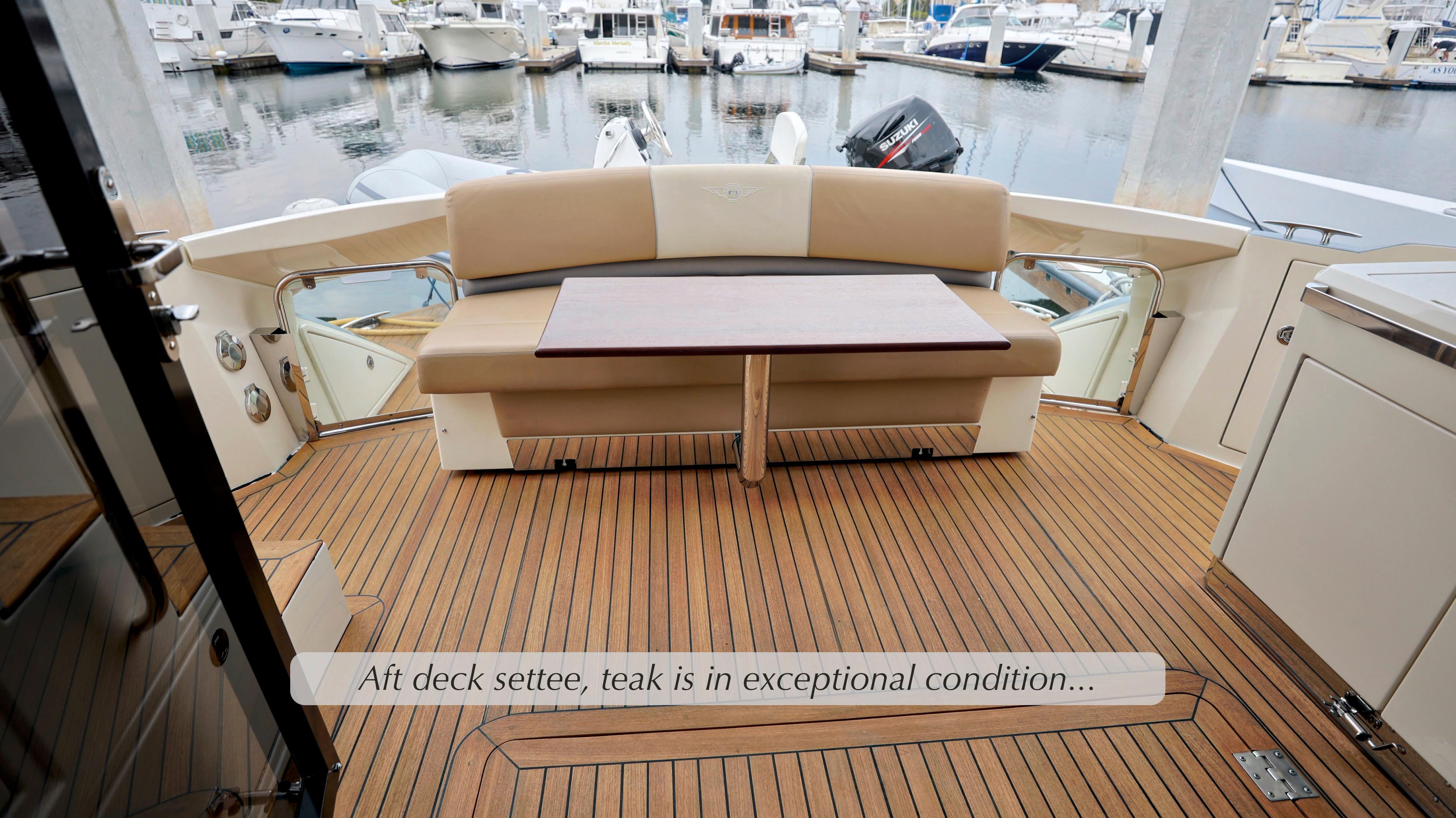 Aft deck settee on 2013 Marquis 500 Sport Bridge with teak flooring in excellent condition.