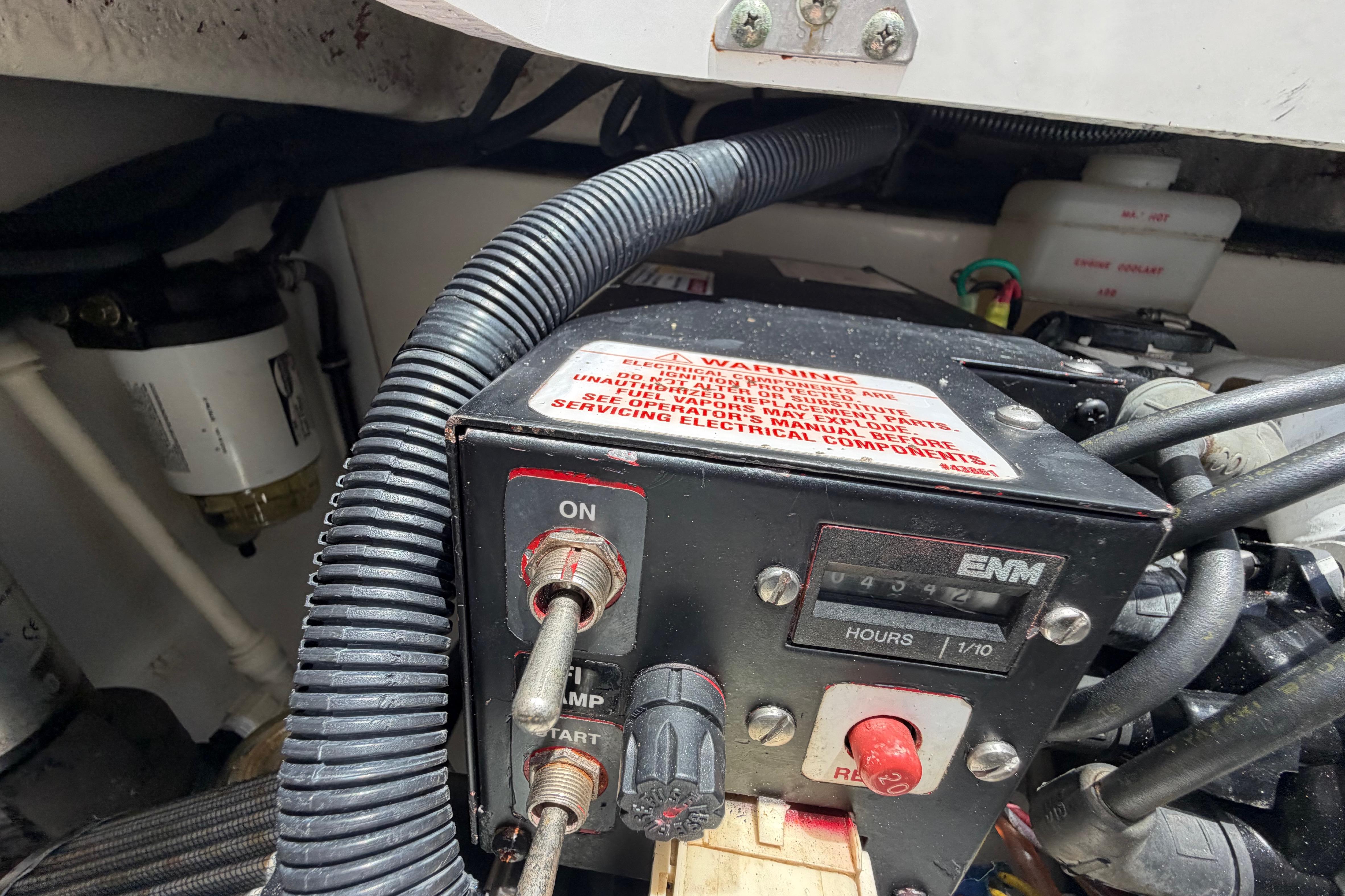 Control panel of a 2009 Everglades 350LX boat with warning label and hour meter.