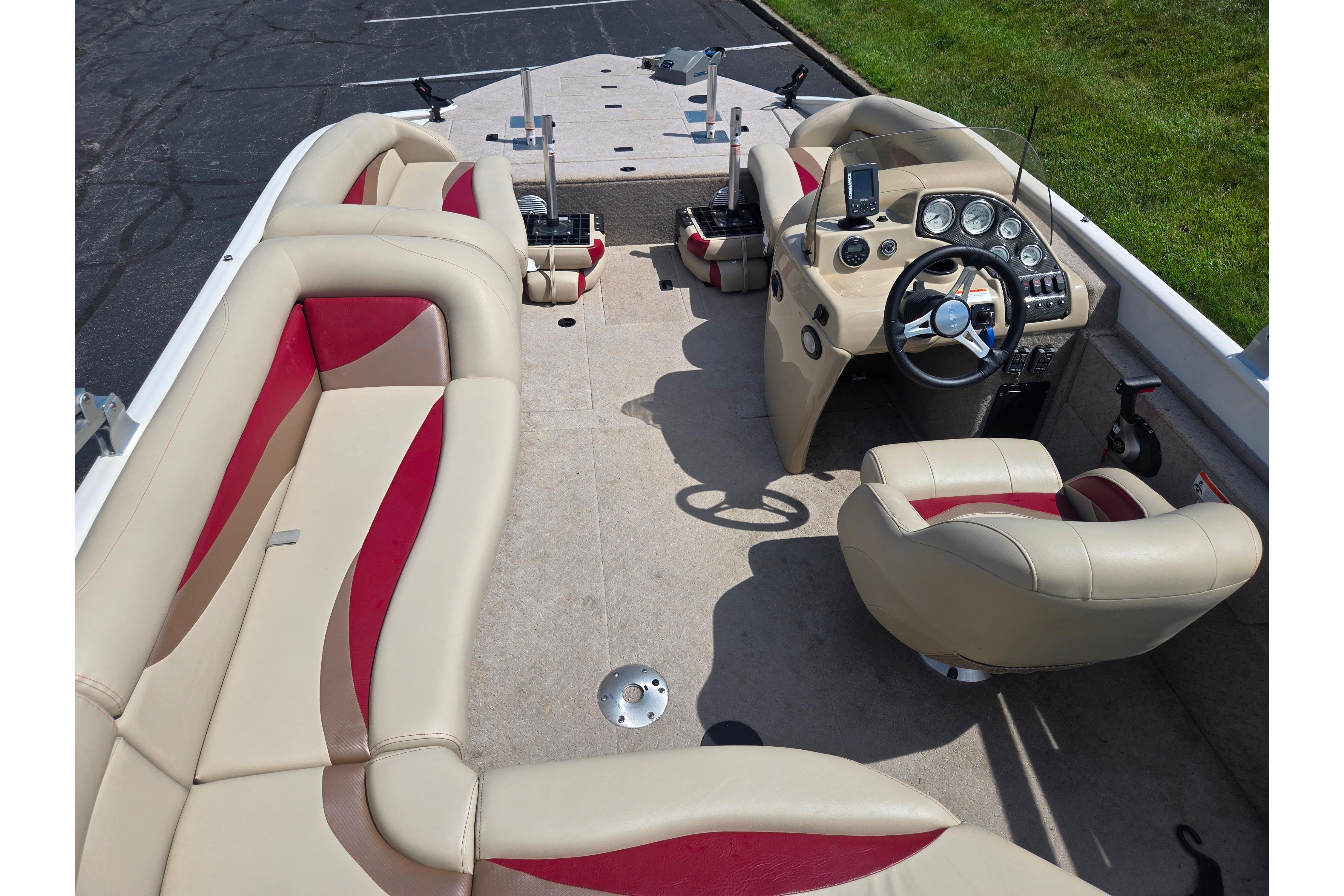 2015 Lowe Sport Deck 224 boat interior with beige and red seating, steering console, and dashboard.