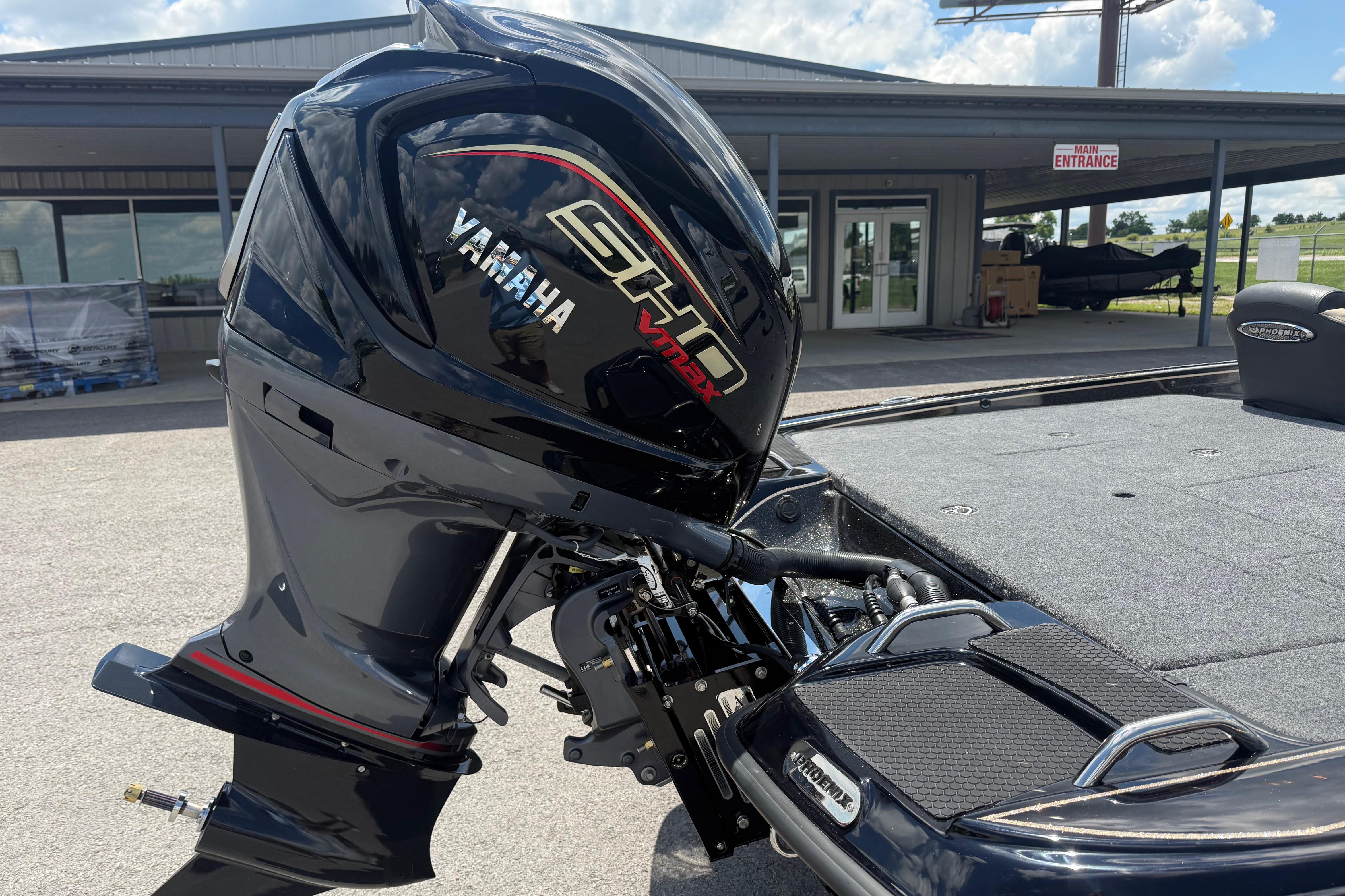 2027 Phoenix 721 ZXL boat with Yamaha engine at dealership entrance.