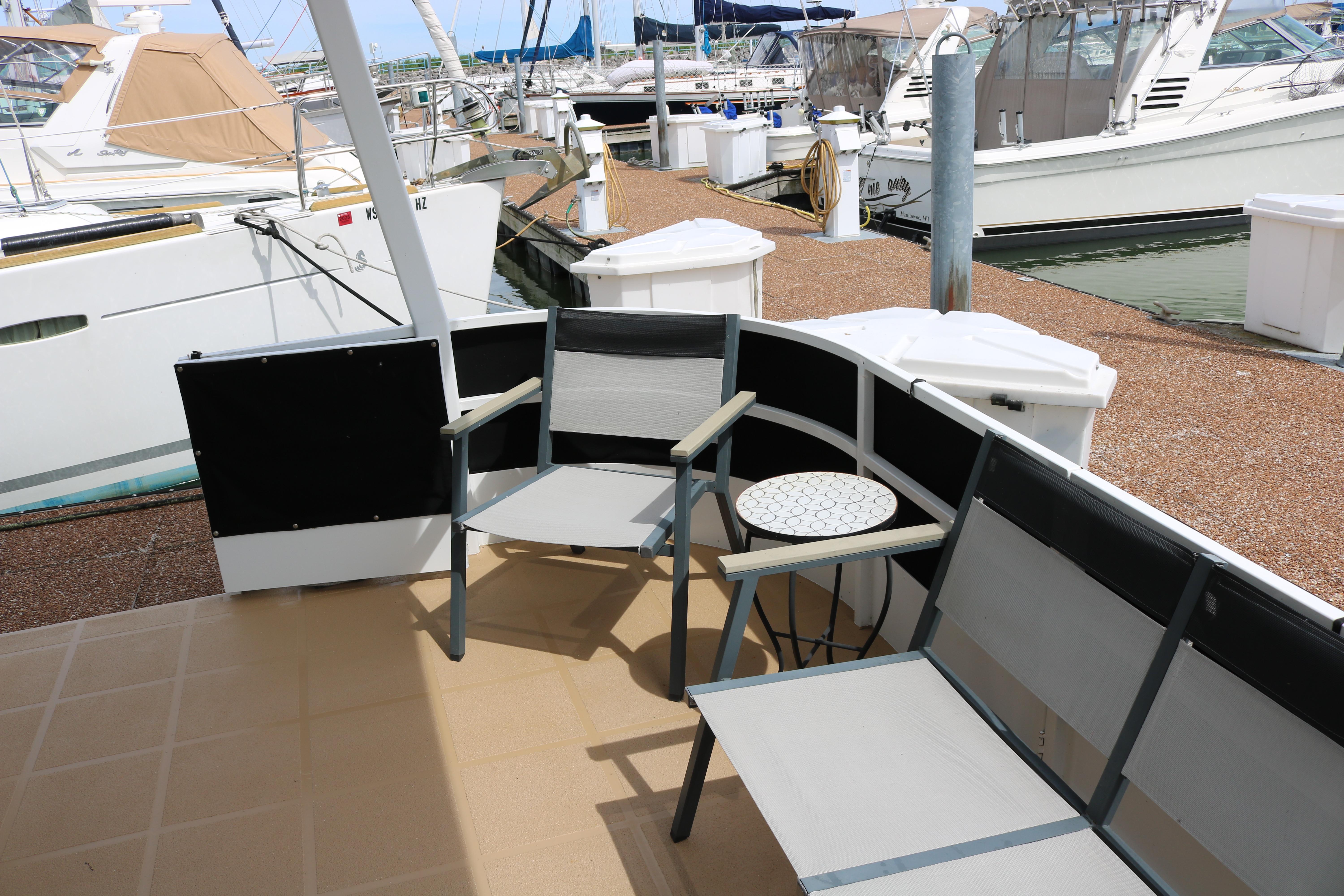 Outdoor seating area on 2010 Skipperliner 480 Flybridge yacht at marina.