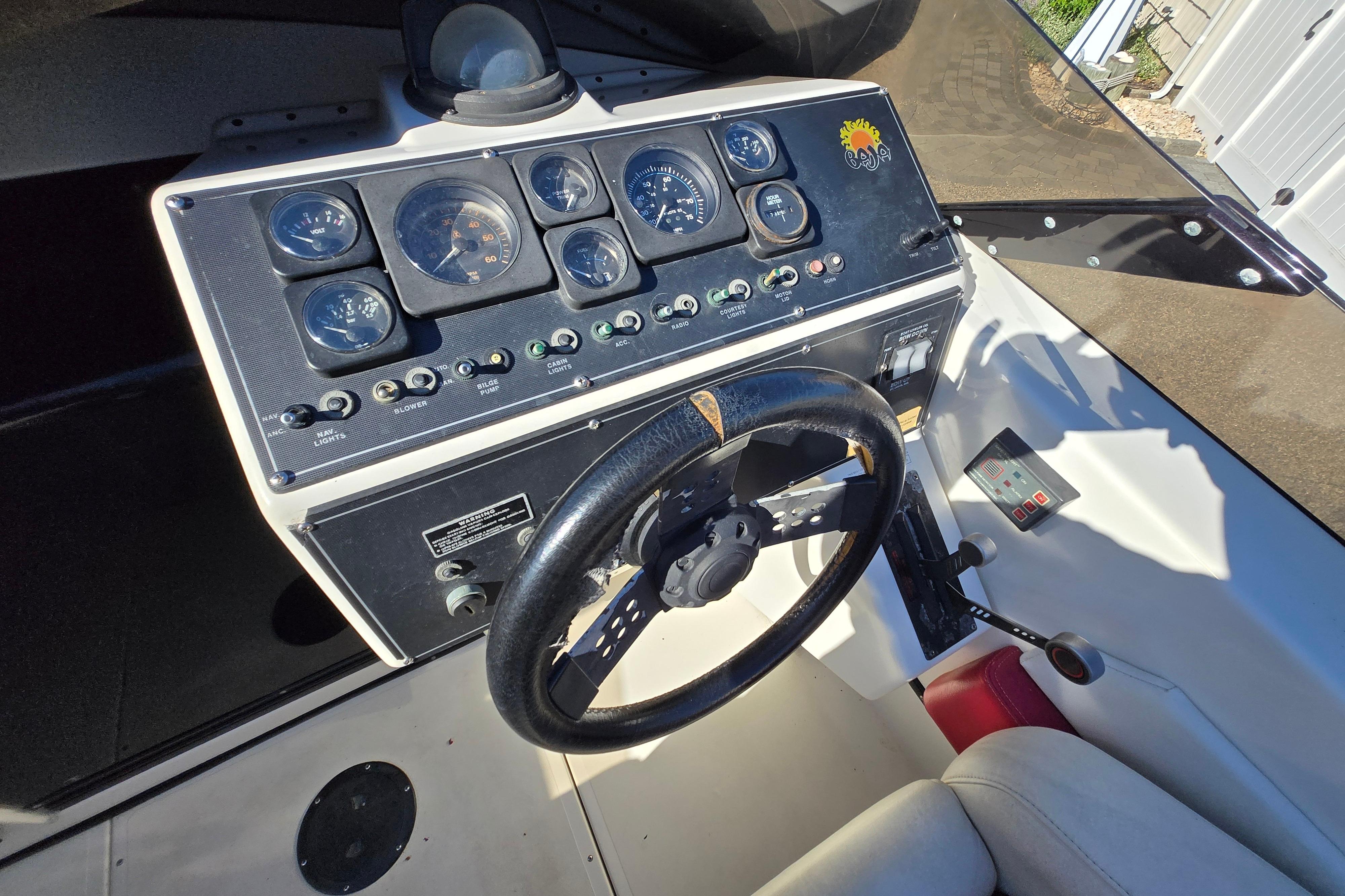 1990 Baja 250 ES boat dashboard with steering wheel and control gauges.