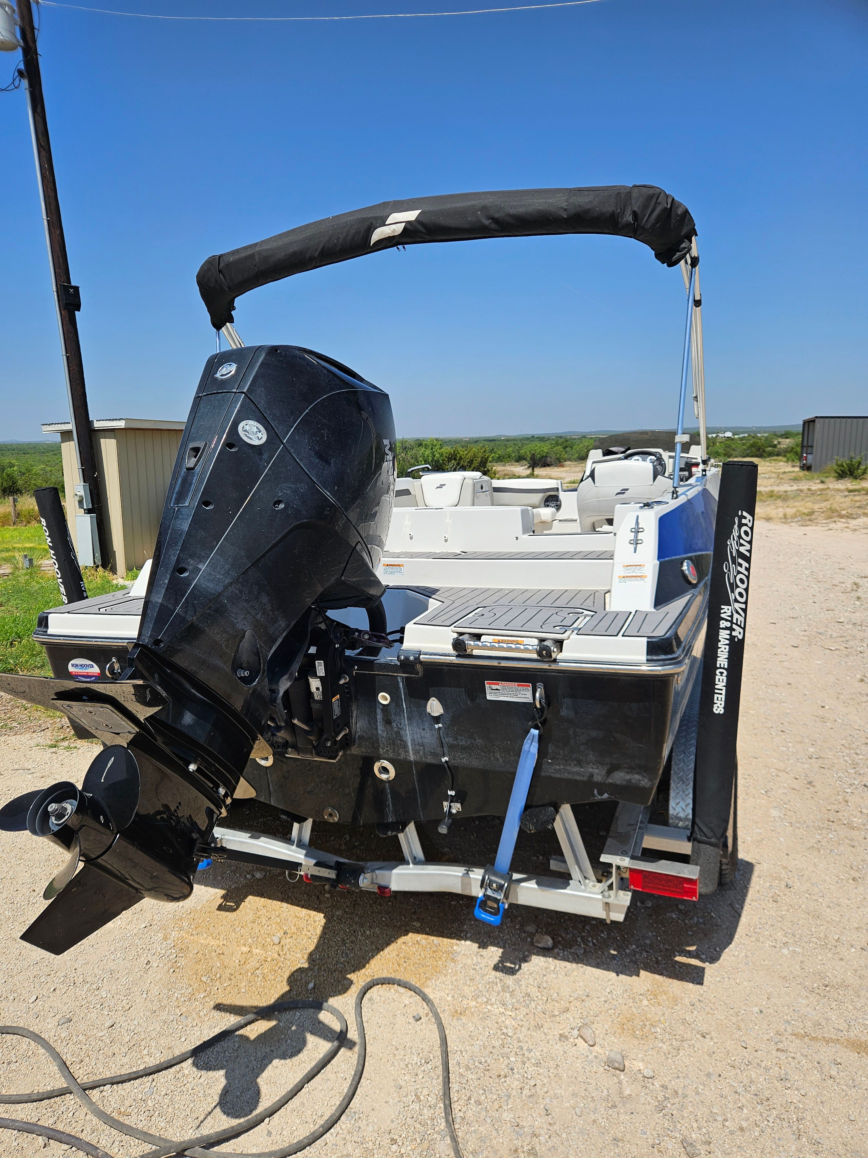A 2023 Starcraft SVX211 boat with an outboard motor, parked on dry land.