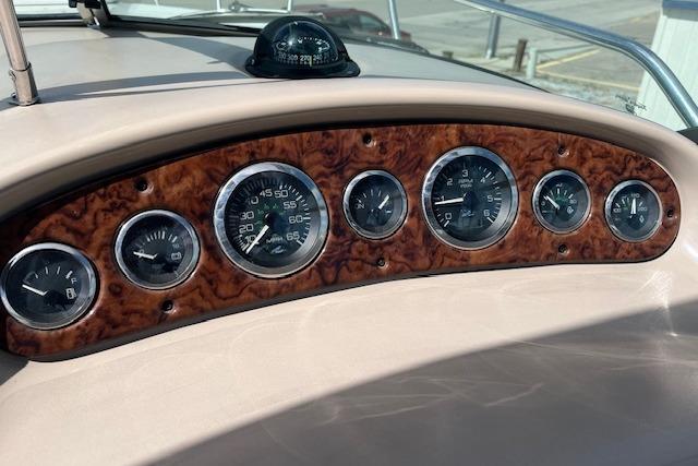 Dashboard of 2003 Sea Ray 260 Sundancer with wood finish and analog gauges.