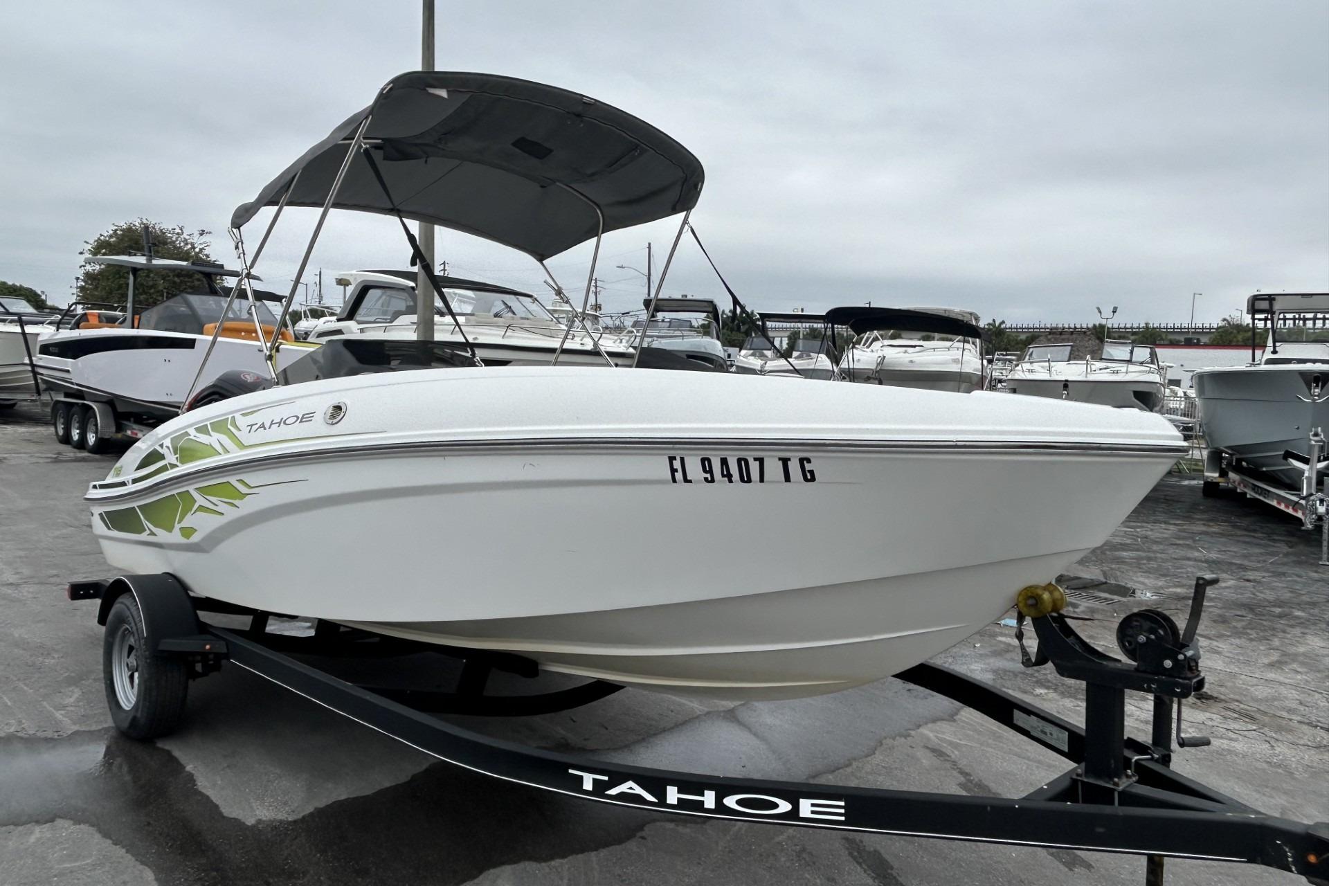 2022 Tahoe T18 boat on trailer, parked in a marina with overcast skies.