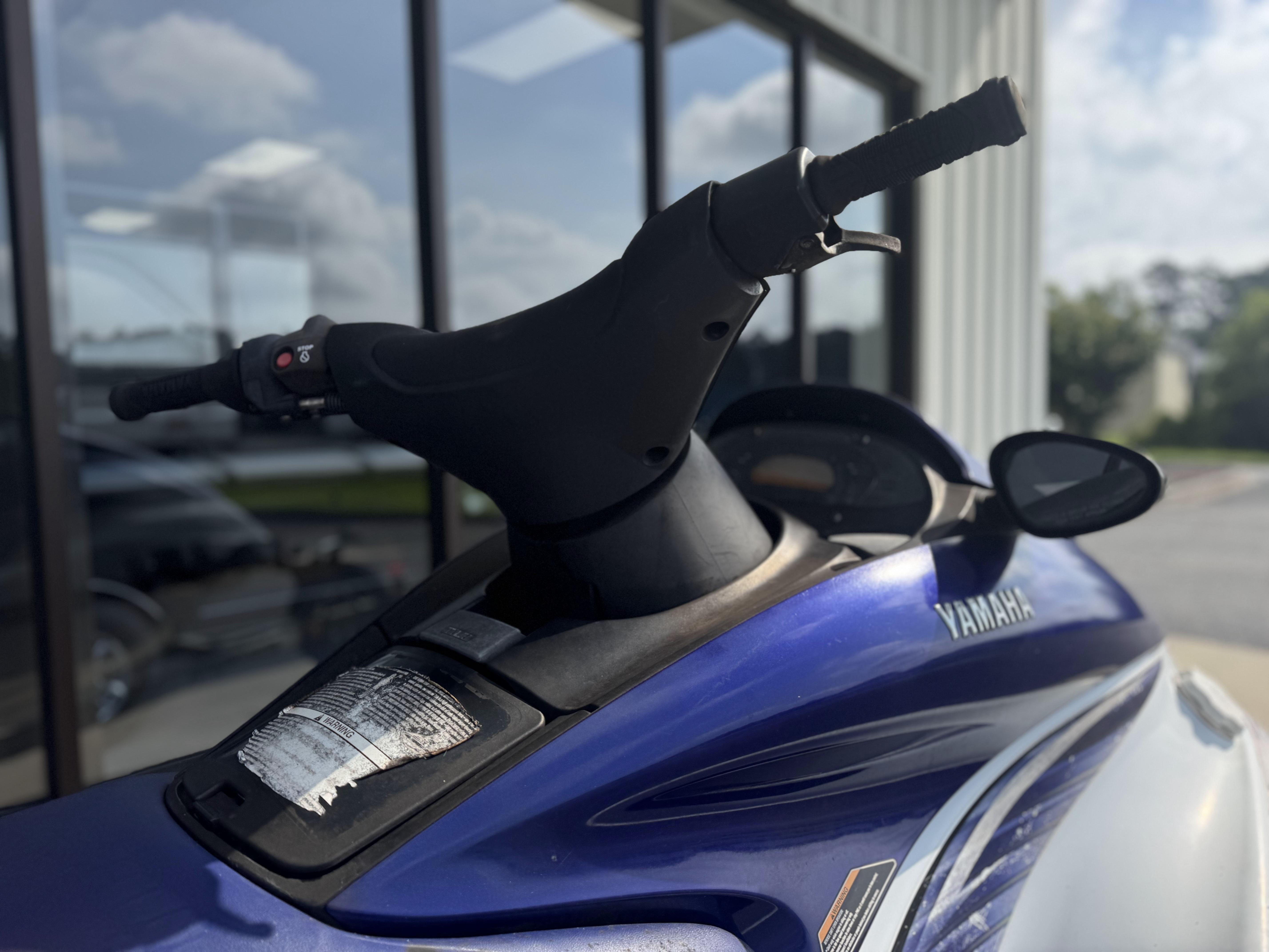 2003 Yamaha WaveRunner FX140 jet ski, blue and white, parked outdoors.