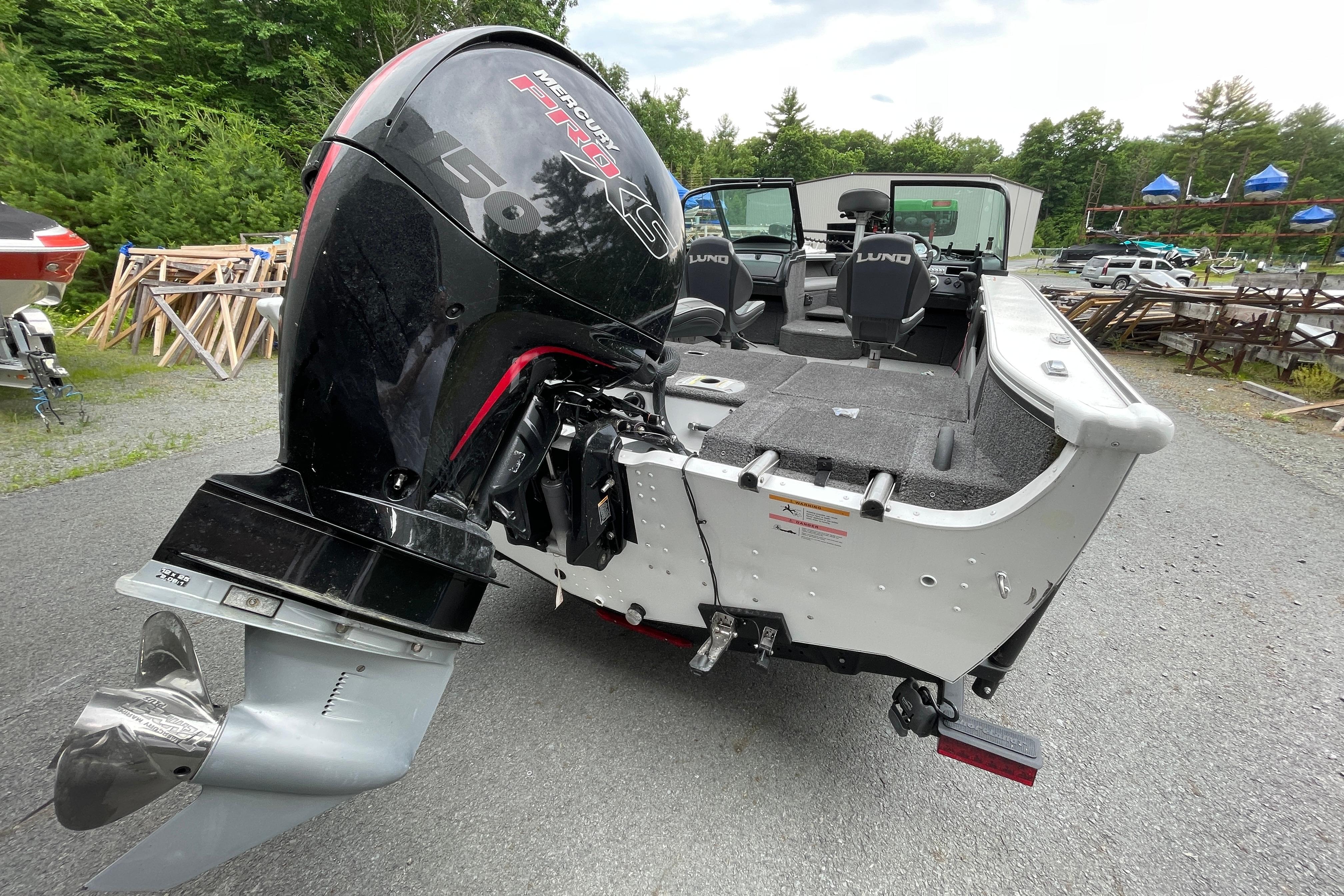 2022 Lund 1875 Crossover XS boat with Mercury Pro XS engine, parked outdoors.