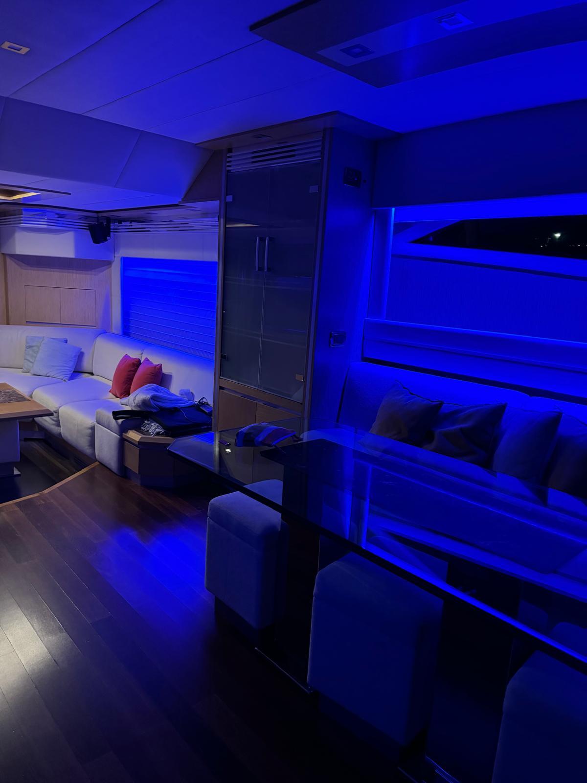 Luxurious 2008 Dominator 680 yacht interior with ambient blue lighting and modern furnishings.