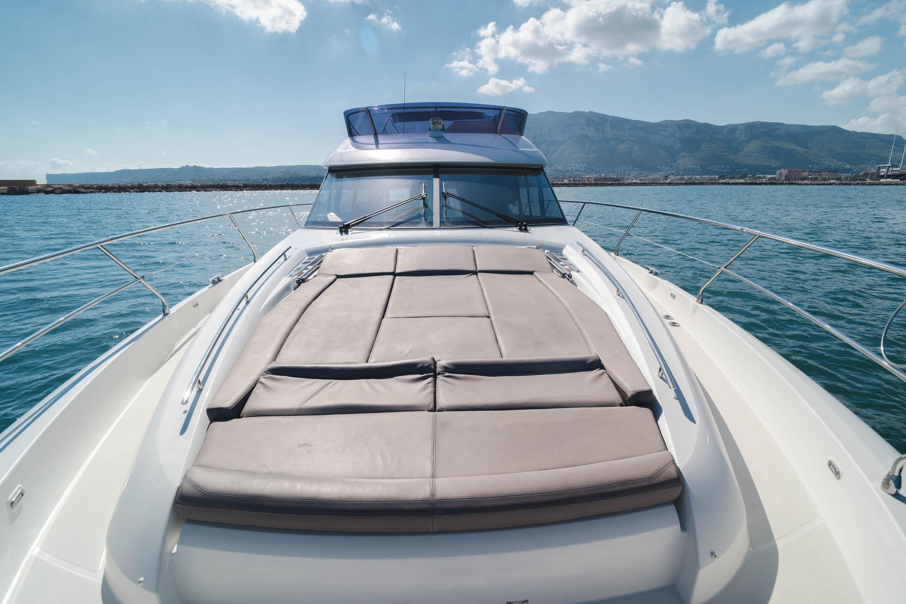 Luxurious 2017 Prestige 560 yacht on serene water with mountain backdrop.