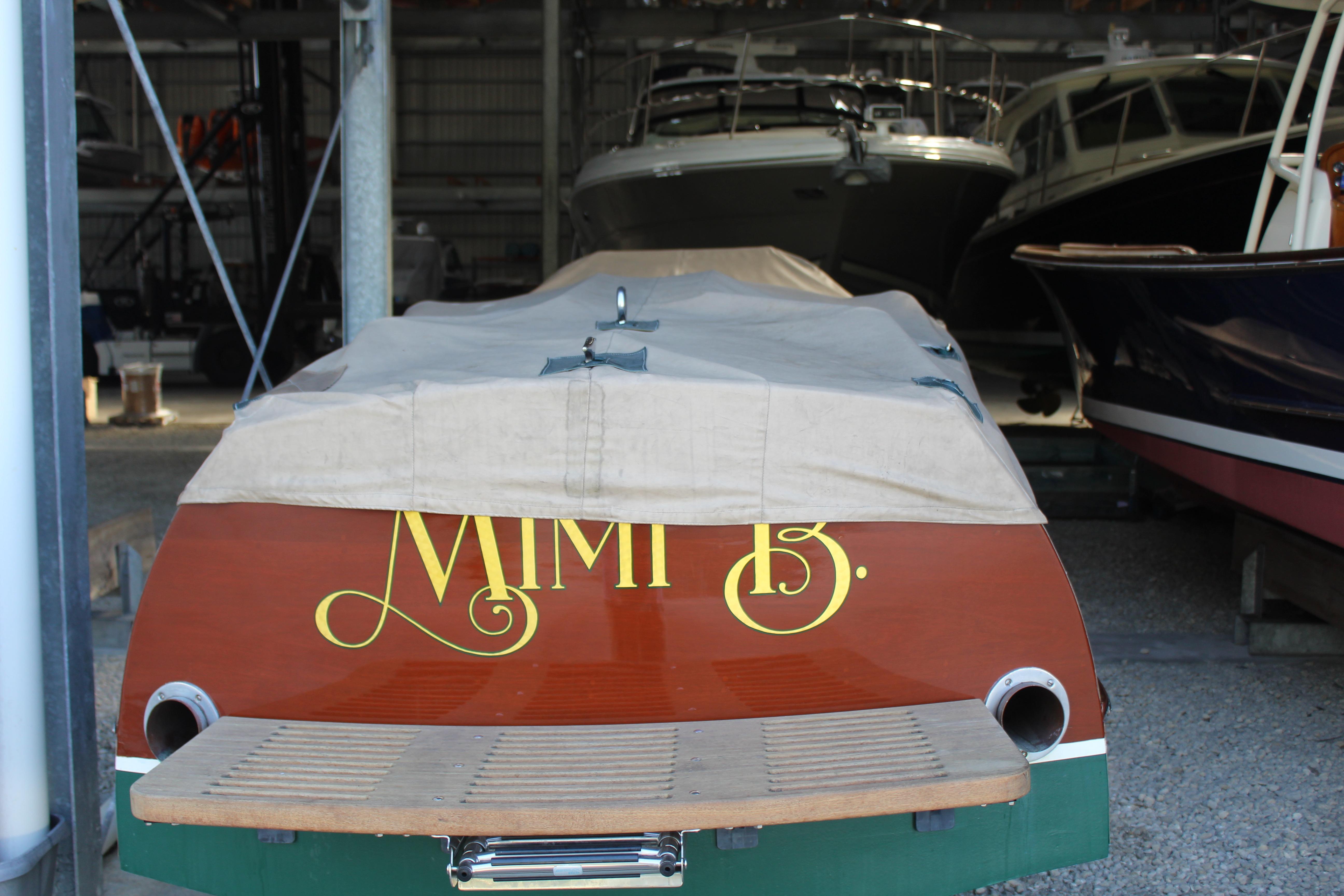 1997 Hacker-Craft 26' Runabout boat covered in storage, rear view.