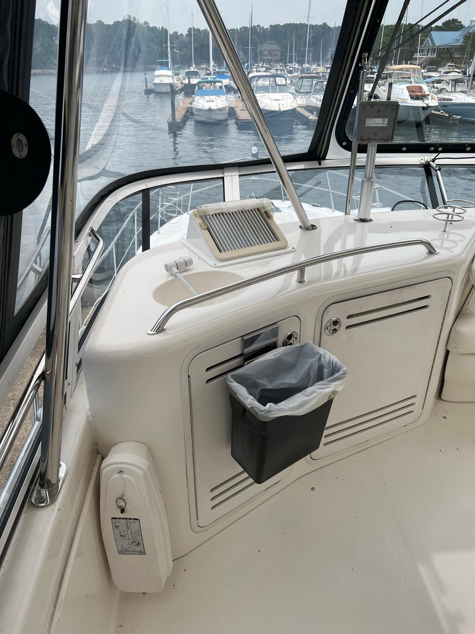 2003 Sea Ray 480 Sedan Bridge helm with marina view in the background.