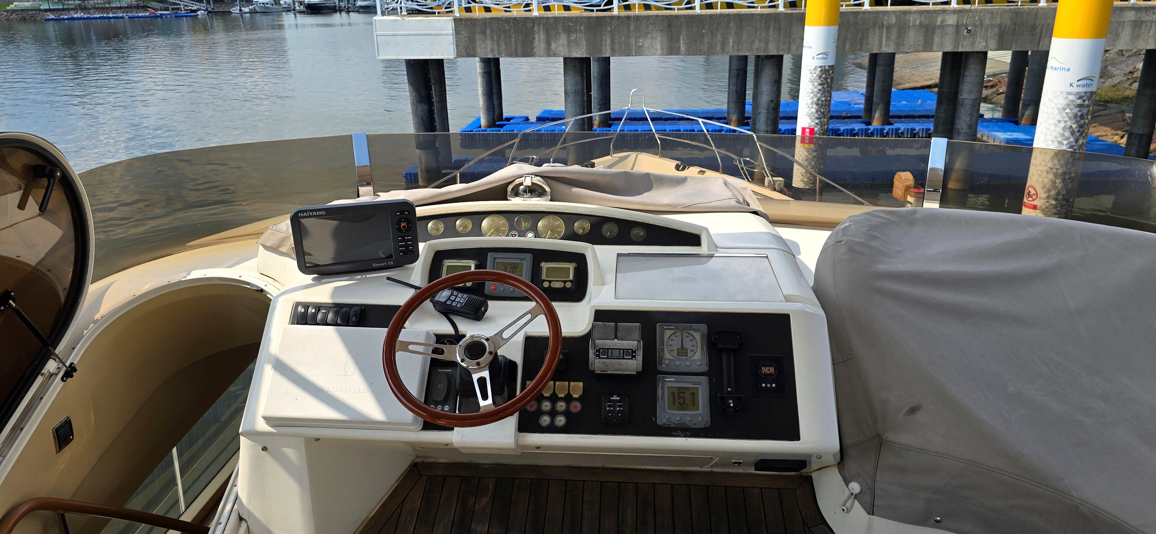 2007 Princess 67 Flybridge yacht helm with steering wheel and navigation equipment.