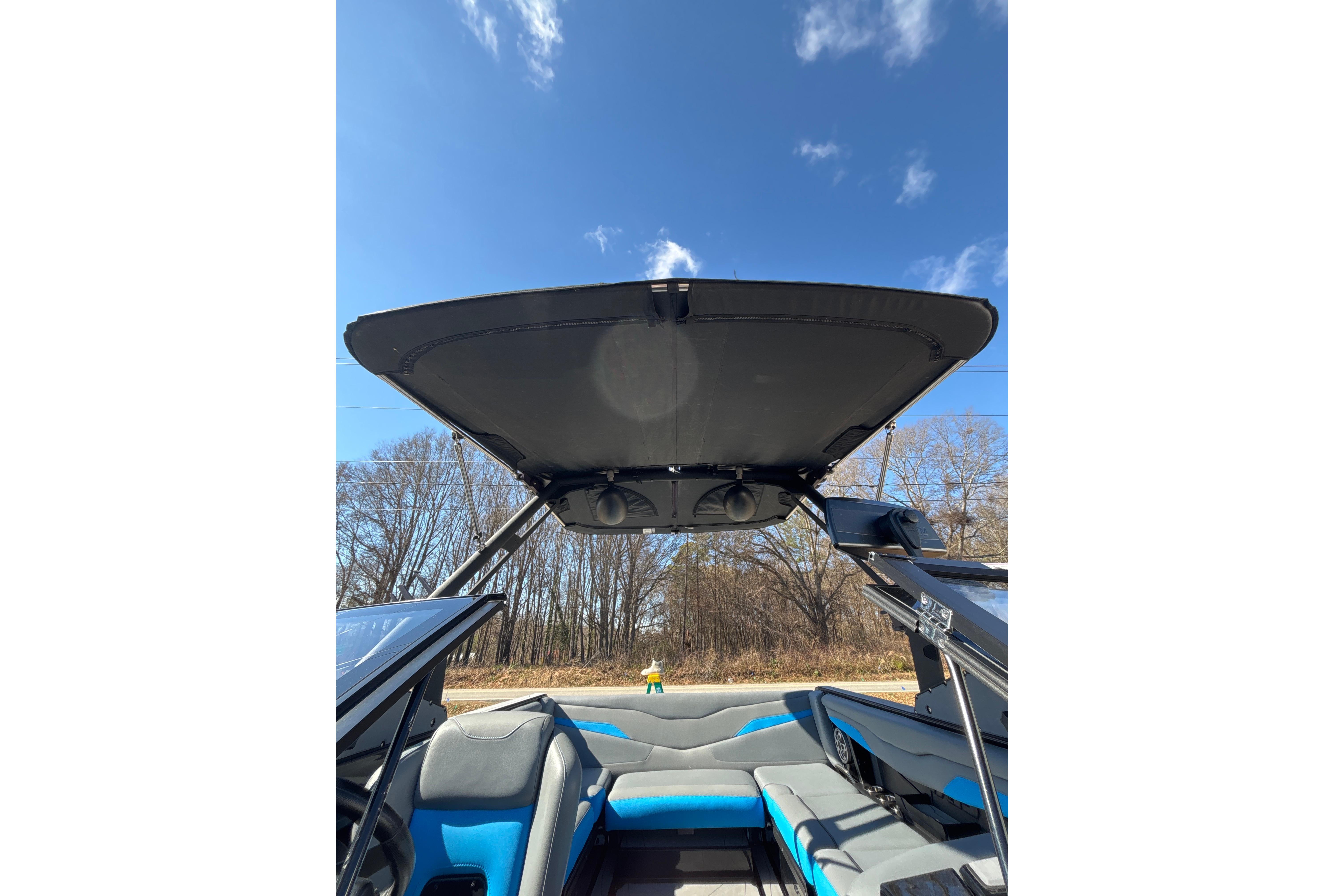 2023 Axis T220 boat interior with open canopy under clear blue sky.