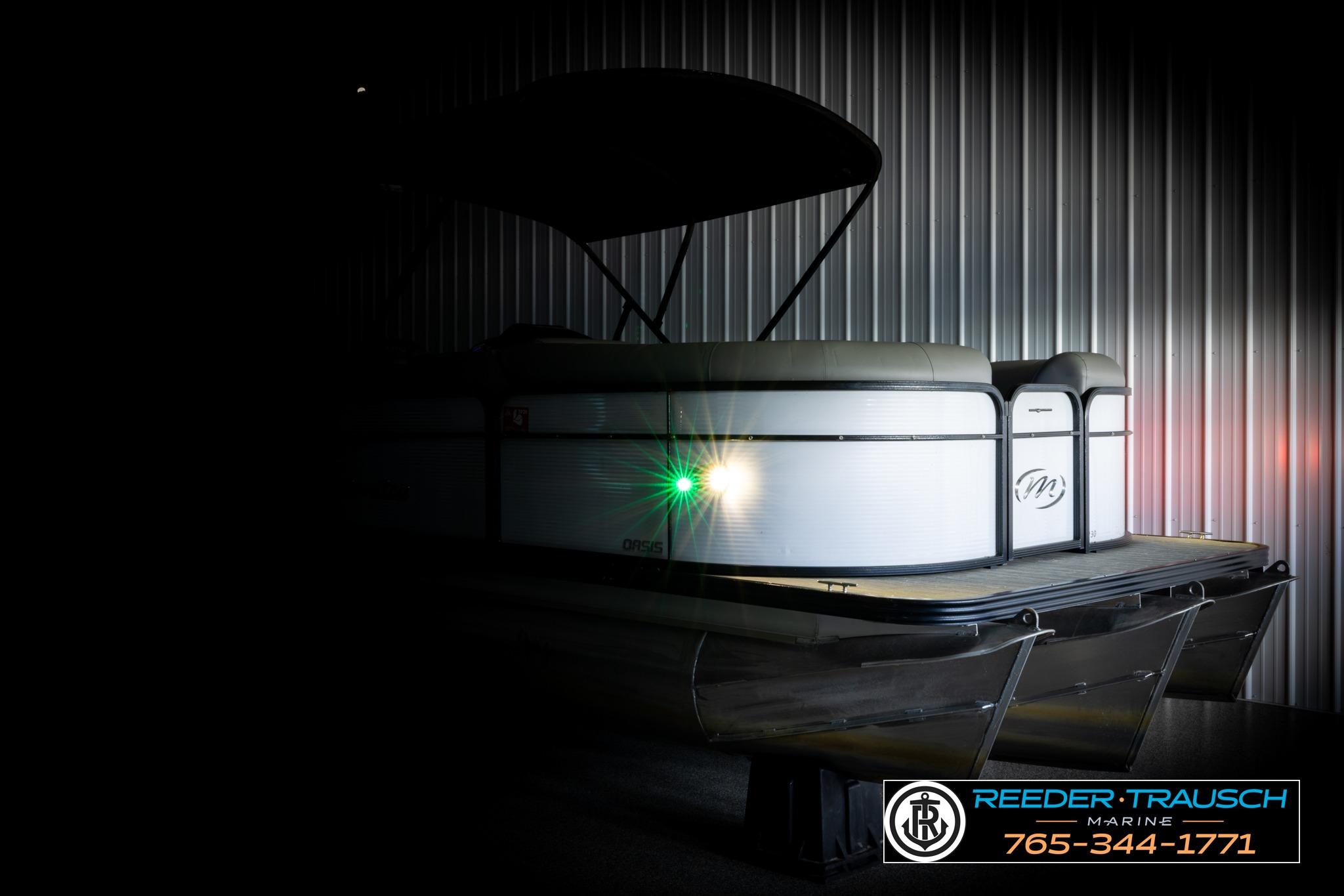 2019 Manitou Oasis SR VP pontoon boat in dimly lit storage, side view.