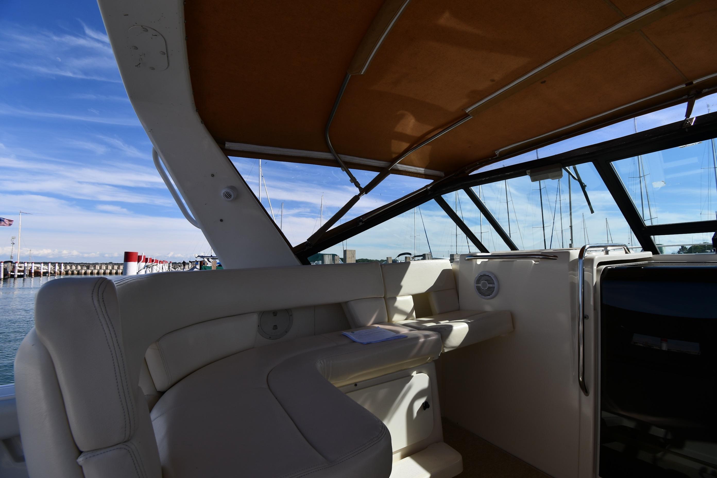 1998 Tiara Yachts 3100 Open interior with seating, docked at marina under blue sky.