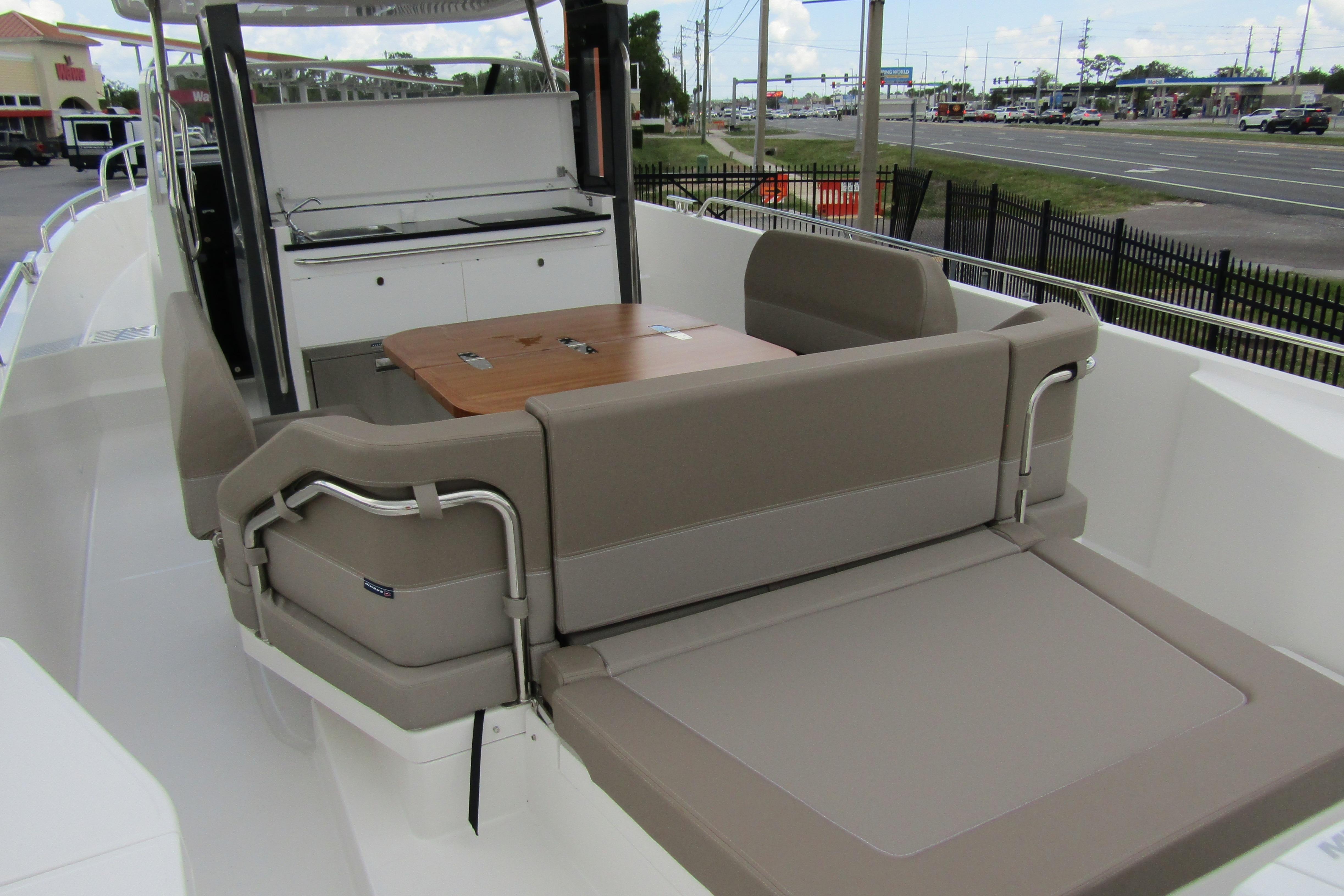 2025 Nimbus Tender 11 boat interior with seating and table, docked near a road.