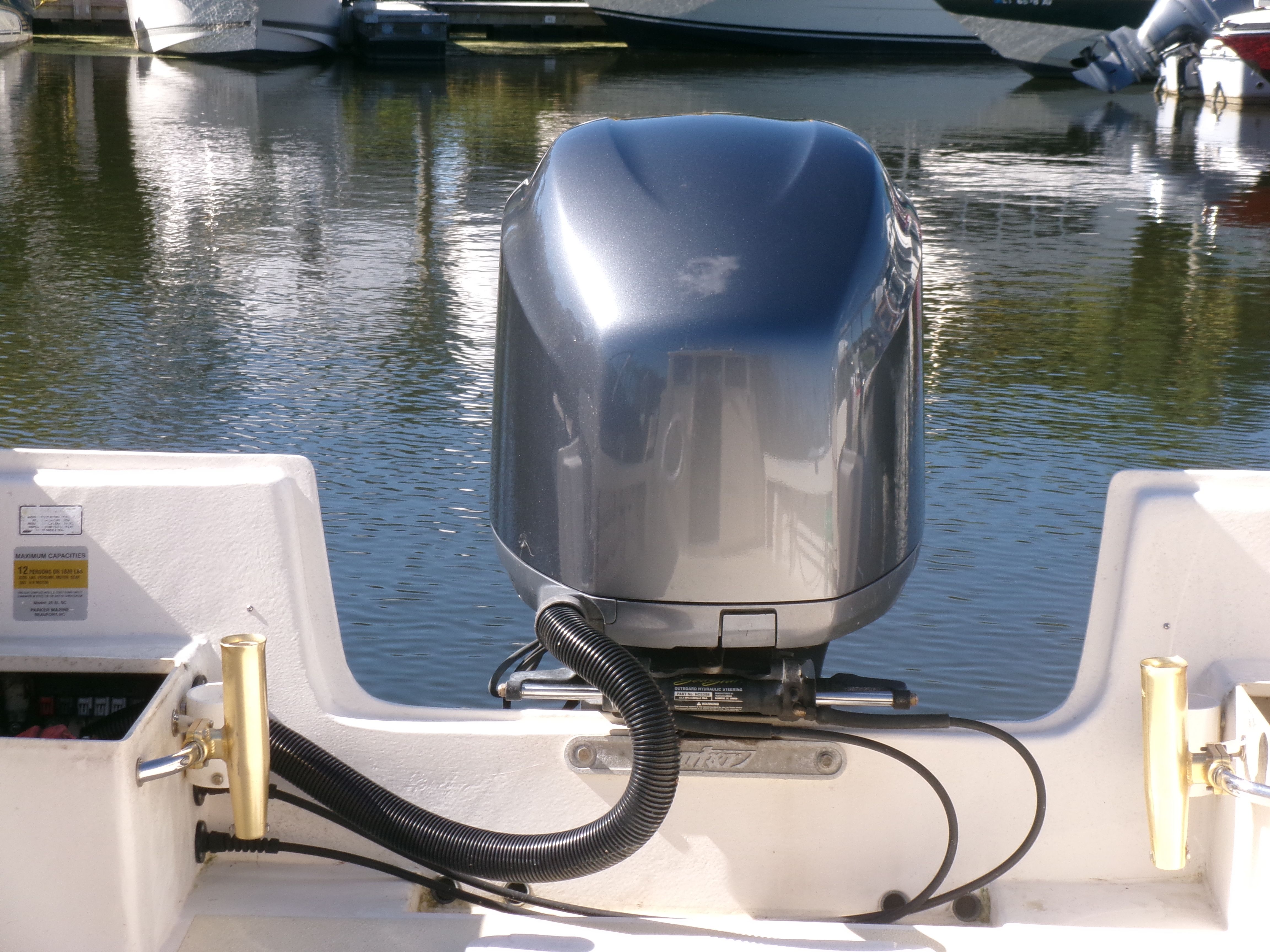 A 2007 Parker 2520 XL Sport Cabin boat with an outboard motor at the stern, on calm water.