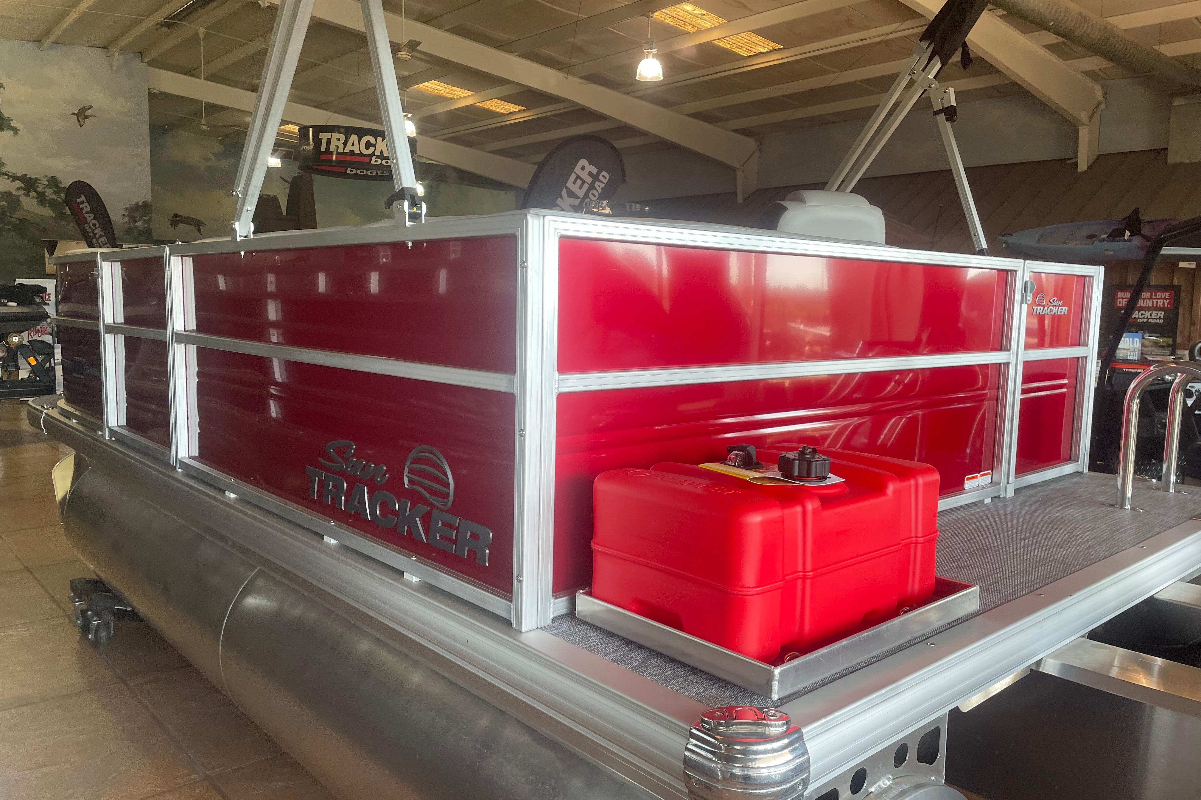 2026 Sun Tracker Party Barge 16 DLX pontoon boat with red exterior in showroom.