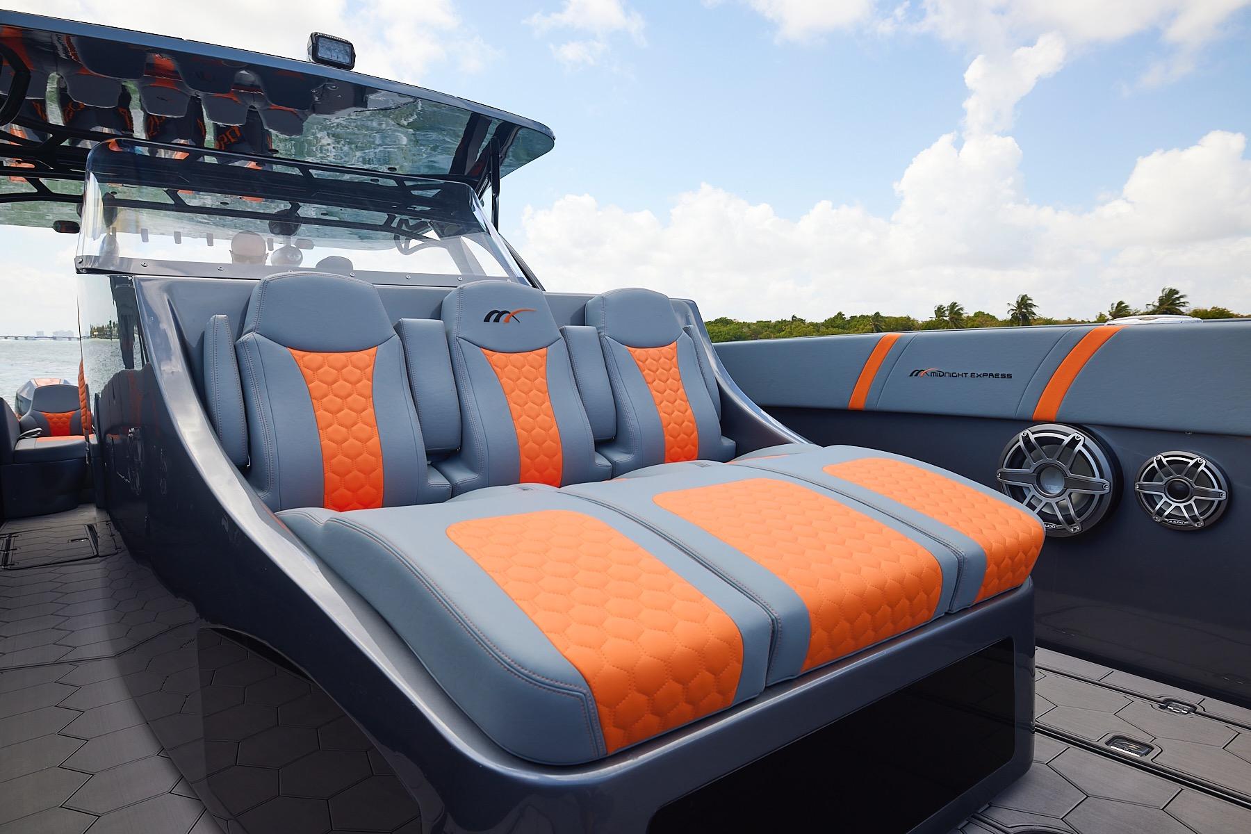 2022 Midnight Express 43 Open boat with stylish orange and gray seating, ocean backdrop.