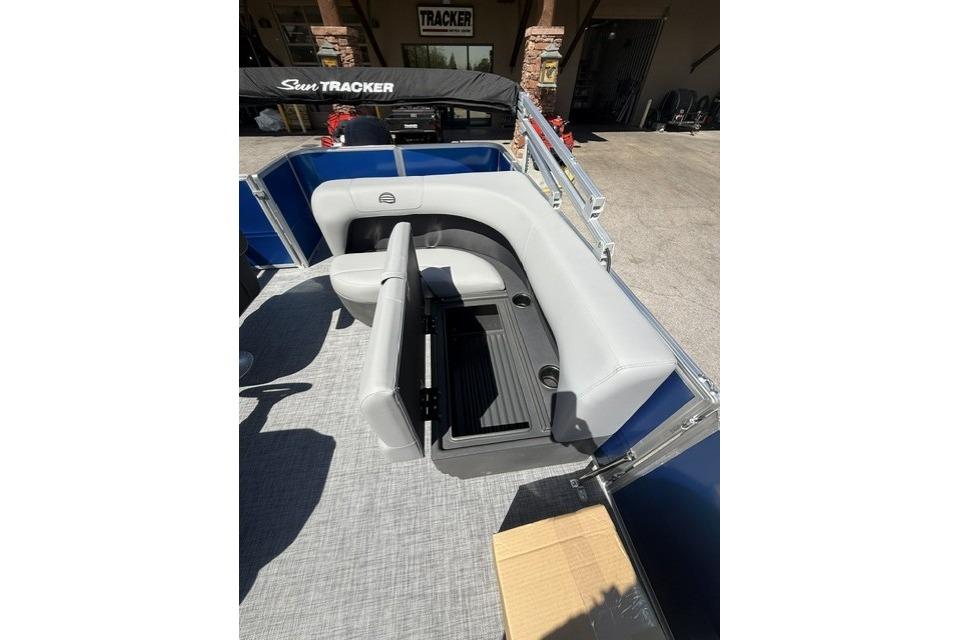 2026 Sun Tracker Party Barge 18 DLX interior with gray seating and storage compartment.