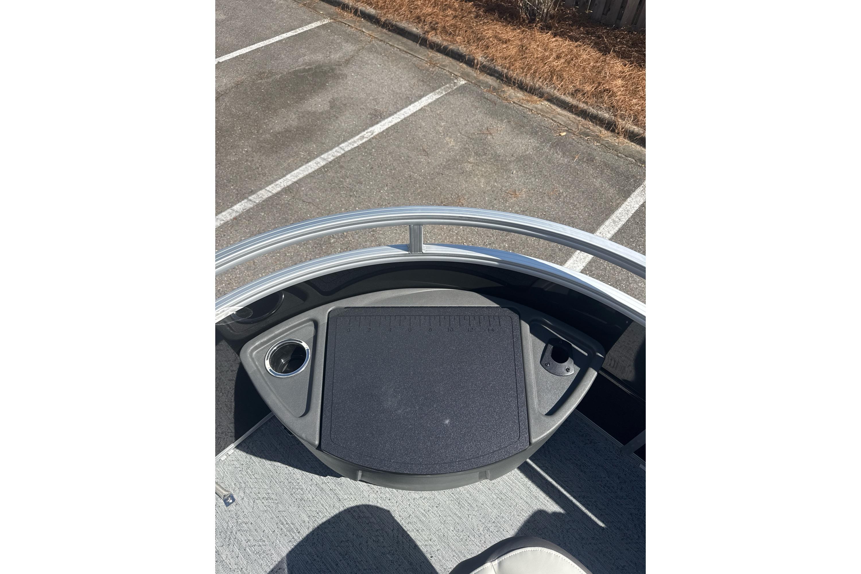 2026 Sun Tracker Fishin' Barge 20 DLX deck view with cup holder and railing.