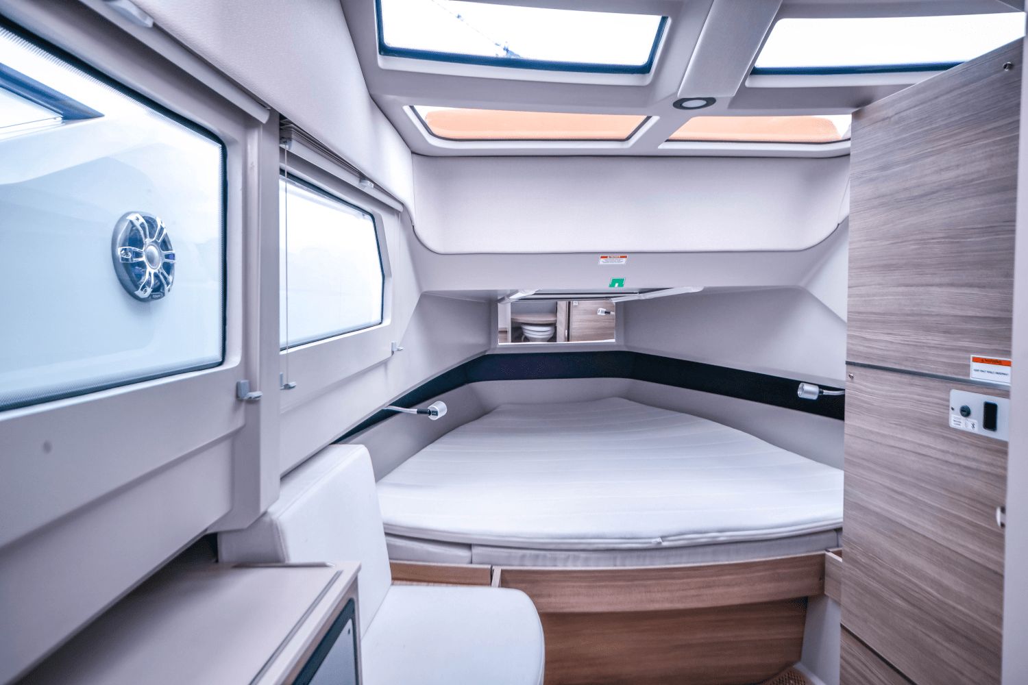 Interior of a modern cabin with large windows and a cozy bed.
