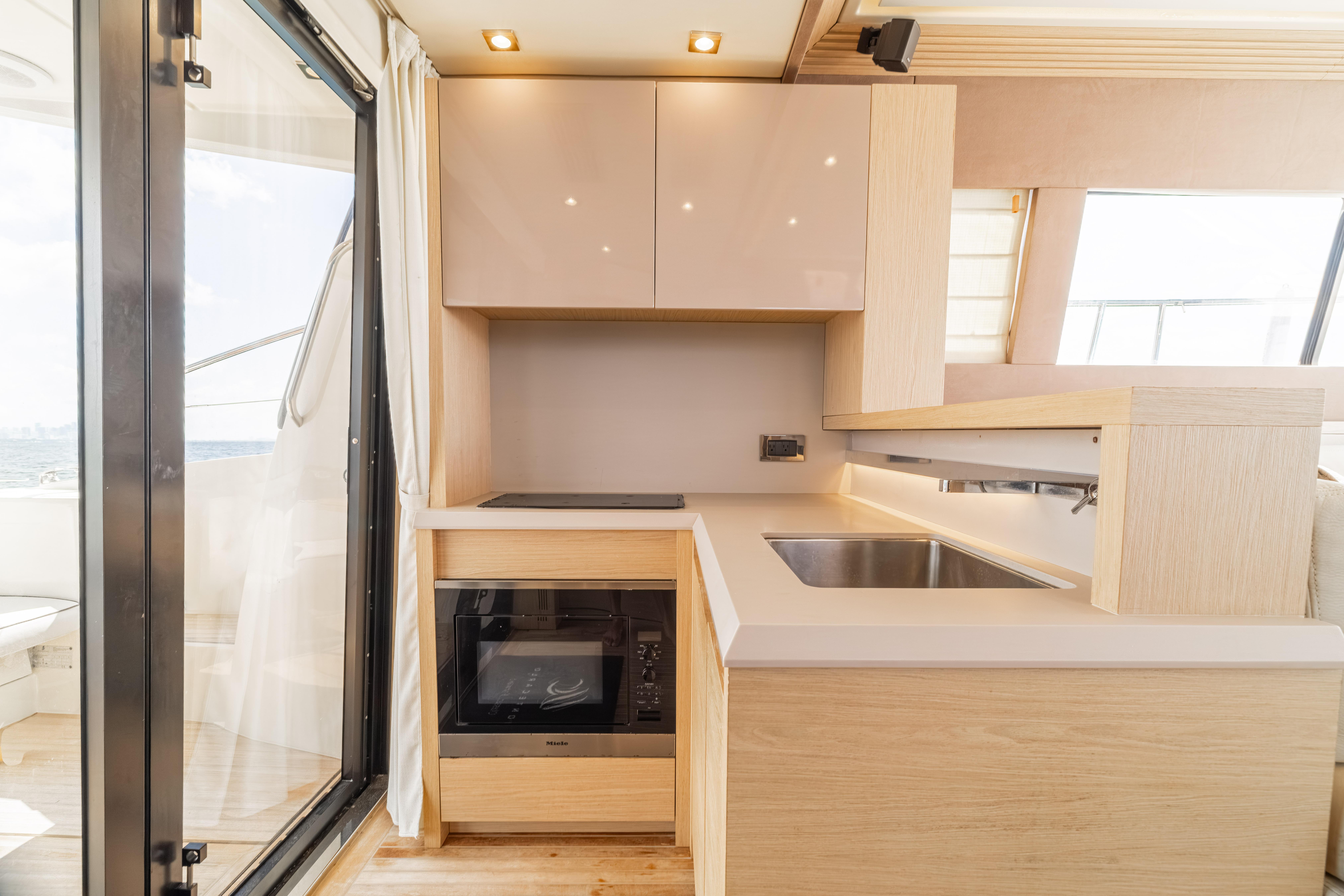 Modern kitchen interior on 2017 Monte Carlo Yachts MC5, featuring sleek cabinetry and appliances.