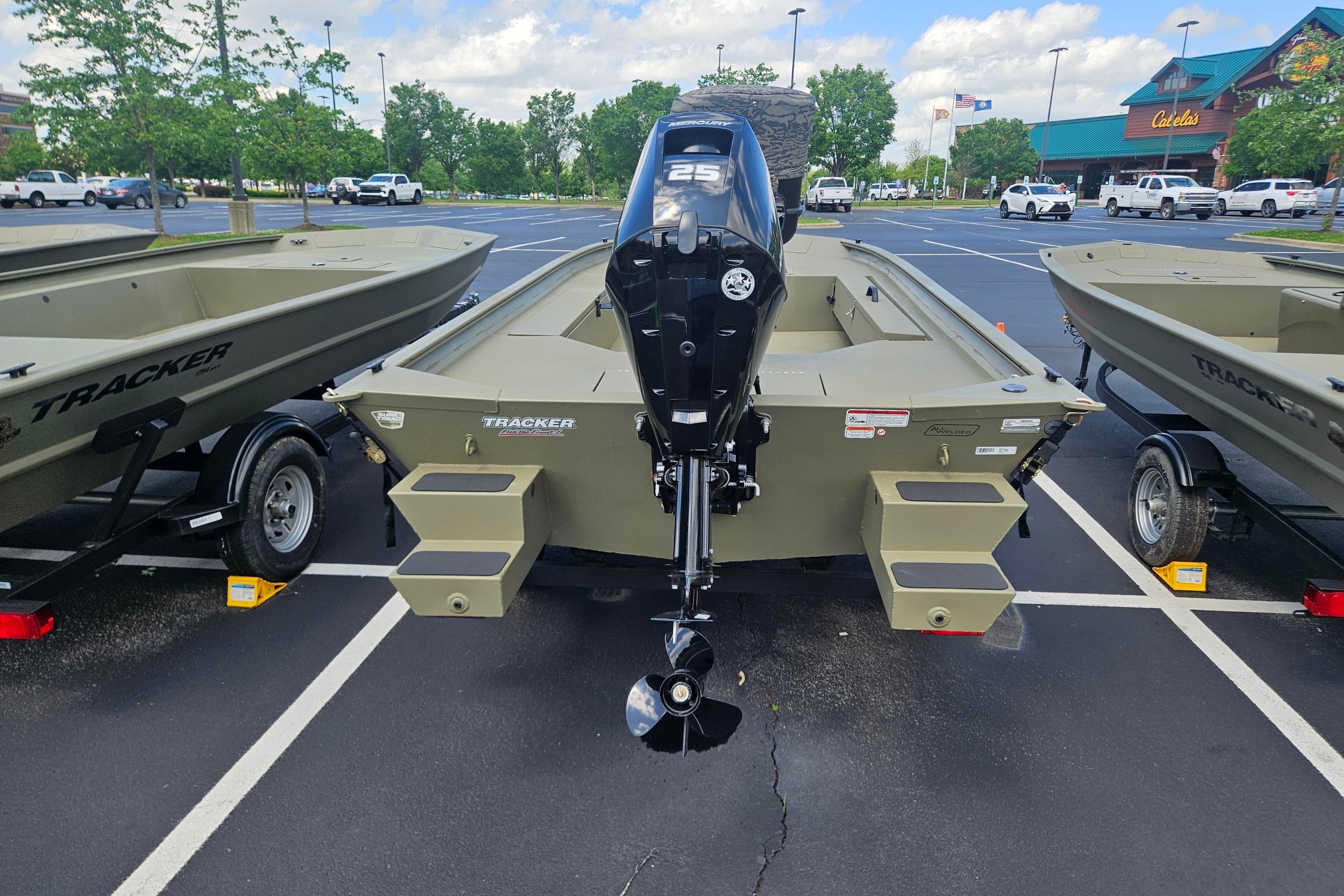2026 Tracker Grizzly 1654 T Sportsman boat with outboard motor in parking lot.