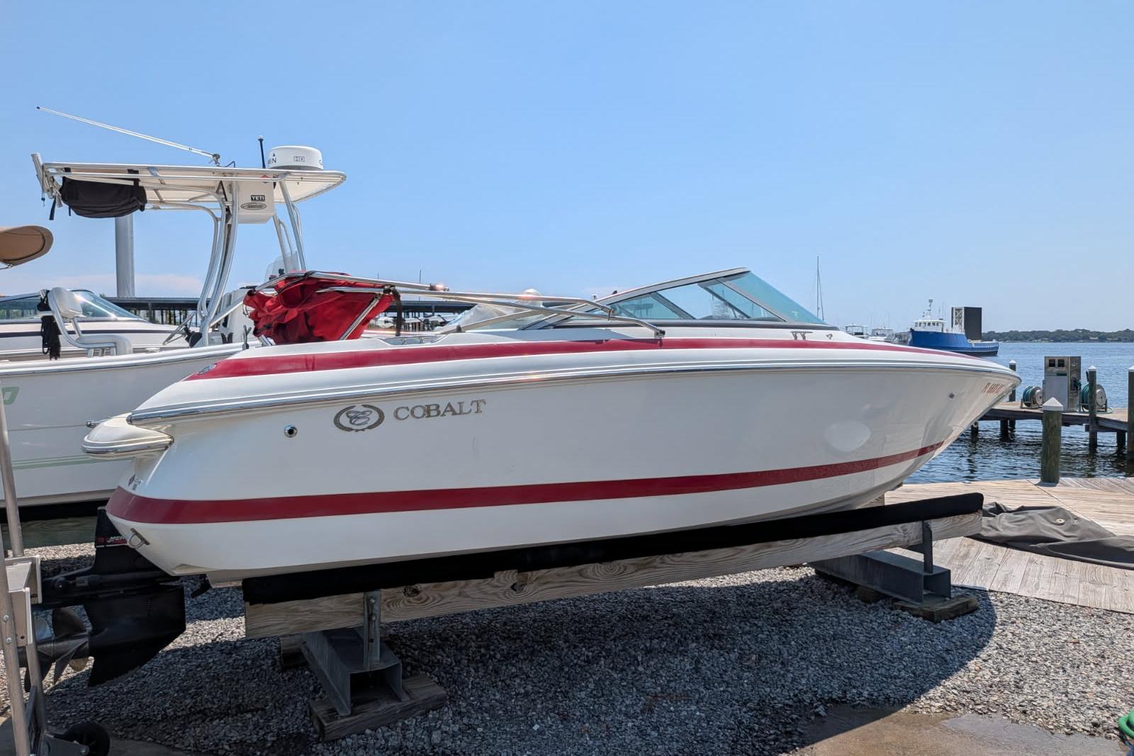 2020 Cobalt 206 boat with red accents docked by the waterfront.