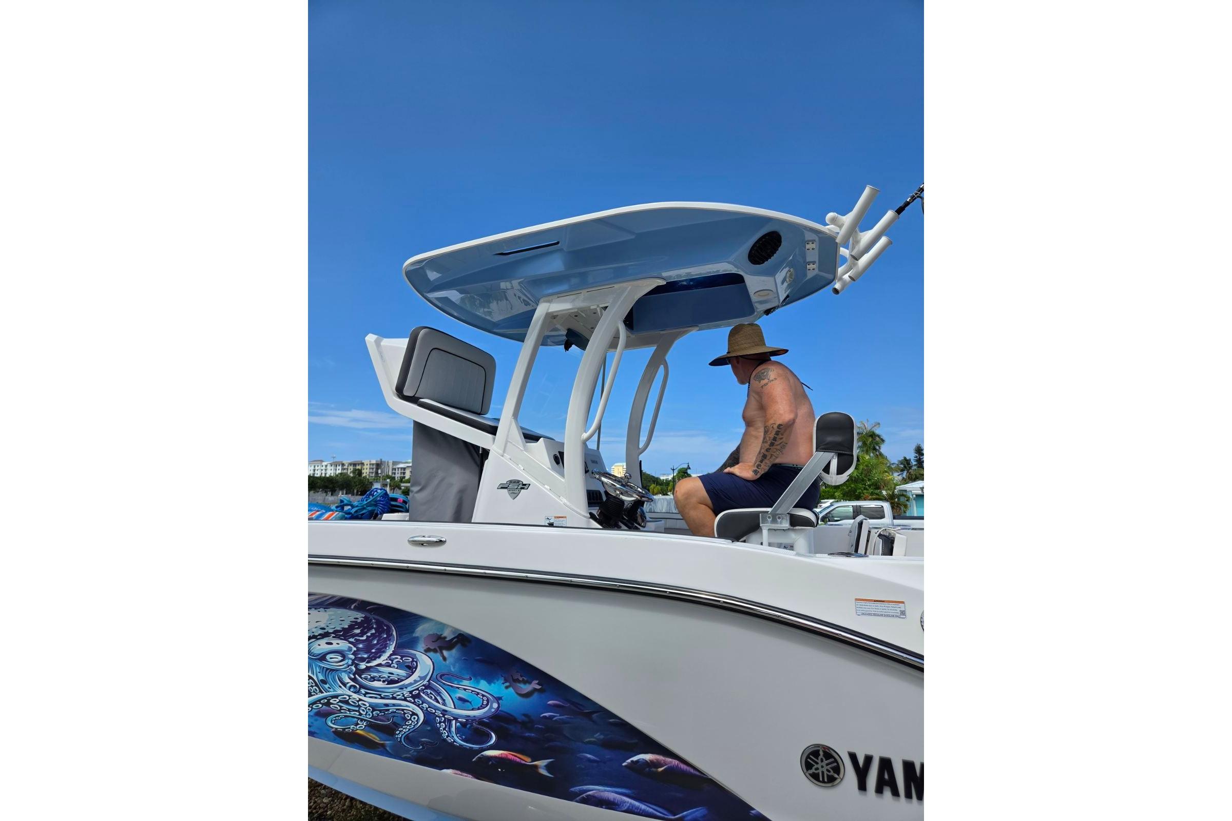 2024 Yamaha Boats 222 FSH Sport E with vibrant marine artwork and a person seated onboard.