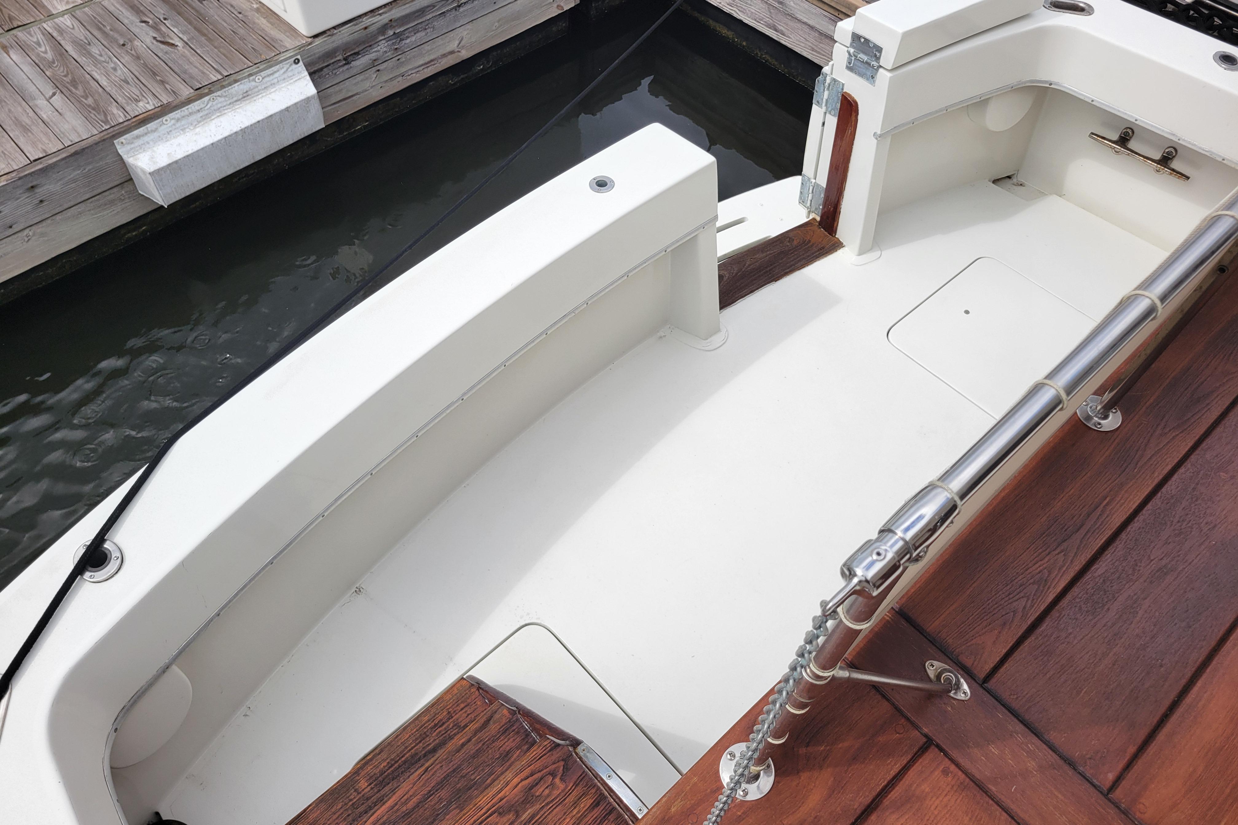 1980 Hatteras 53 Yacht Fisherman deck, featuring white seating and wooden accents.